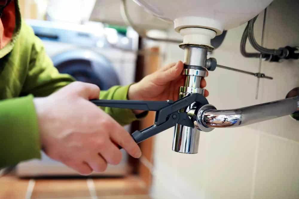 Homeowner realizing the true cost of DIY plumbing repair risks