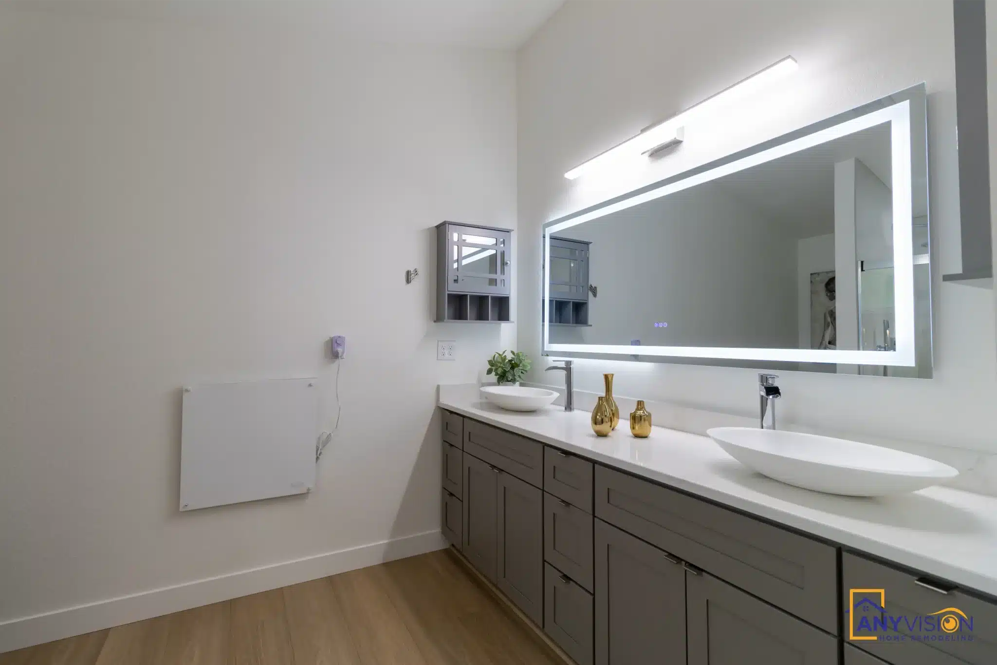Double vanity with backlit mirror and continuous plank flooring