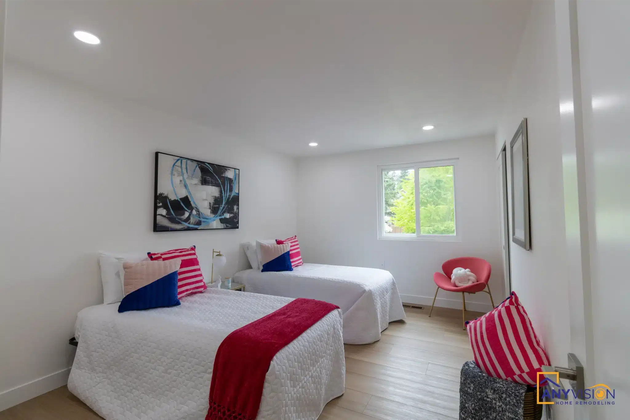 Twin bedroom with window and refinished flooring