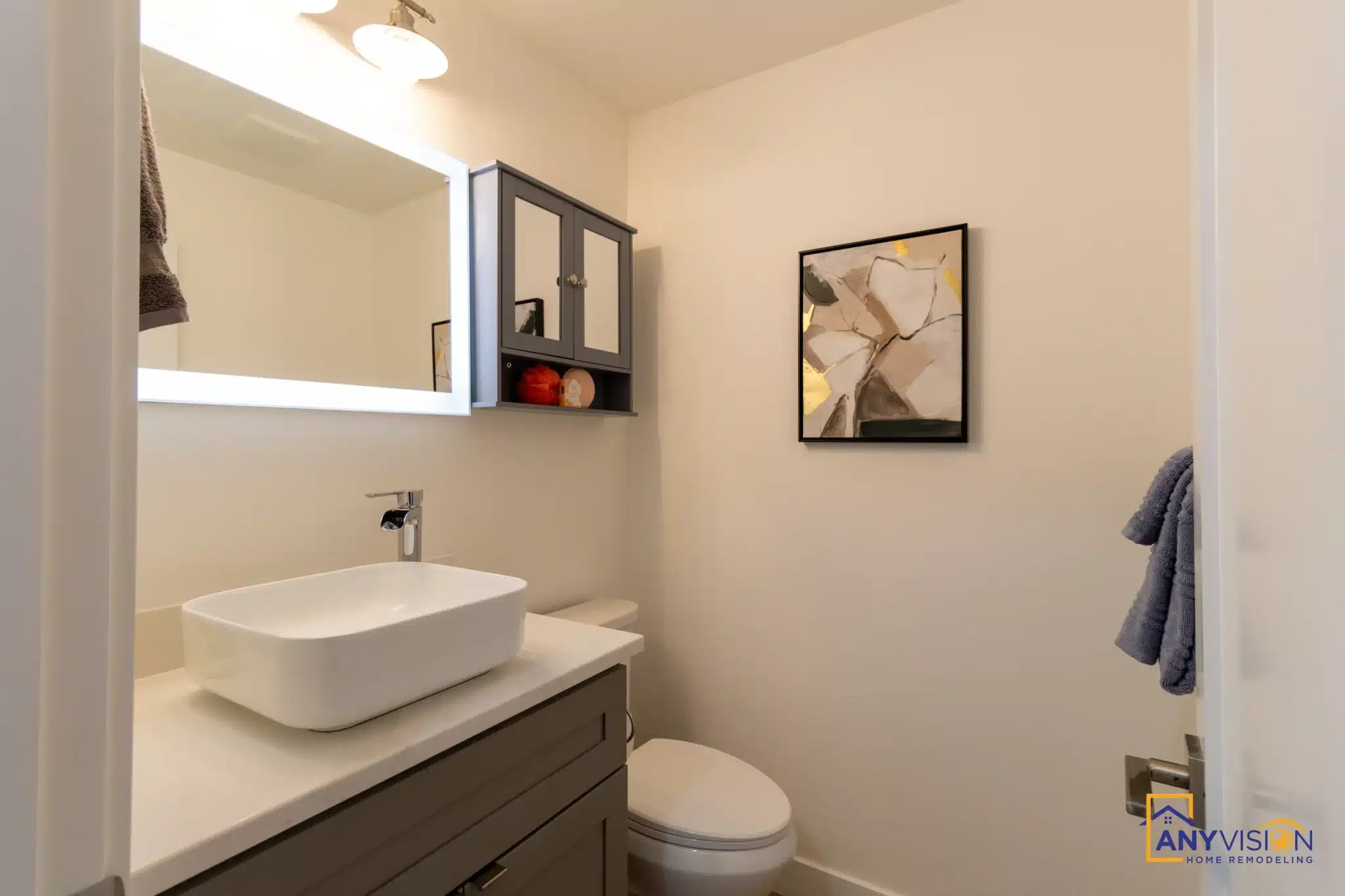 Powder room with vessel basin and backlit mirror