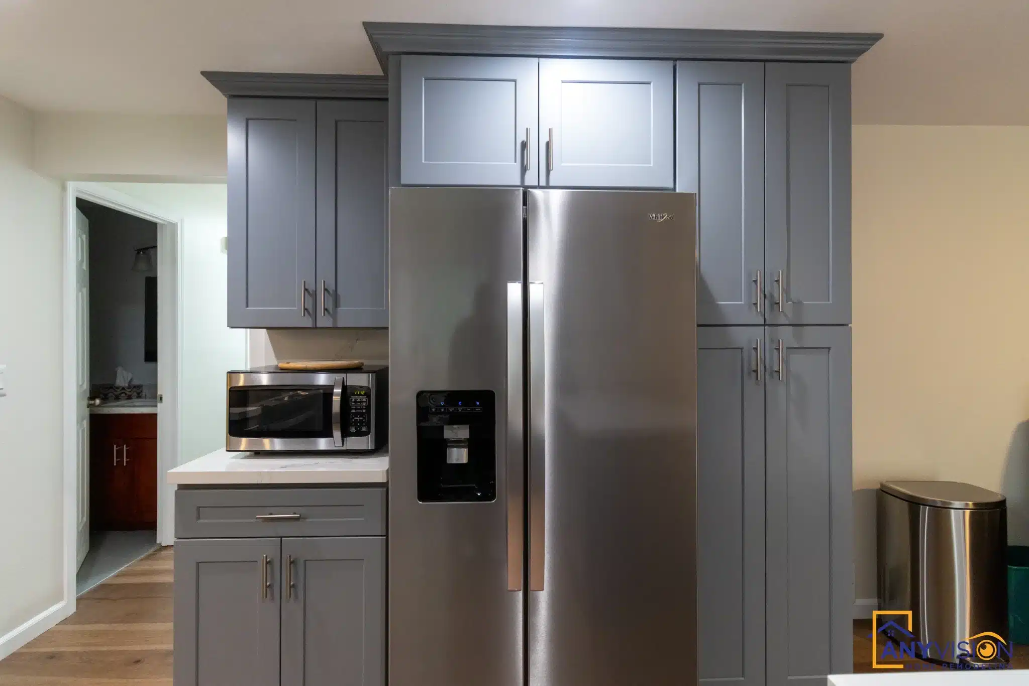 Tall cabinet run beside the stainless refrigerator