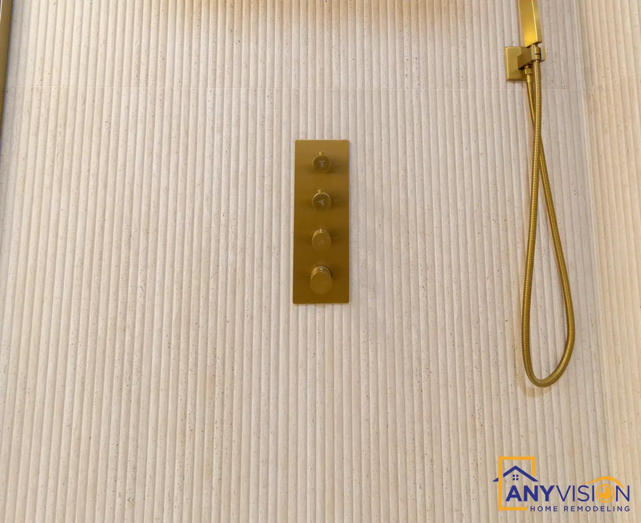 Brushed gold shower controls and handheld on fluted tile