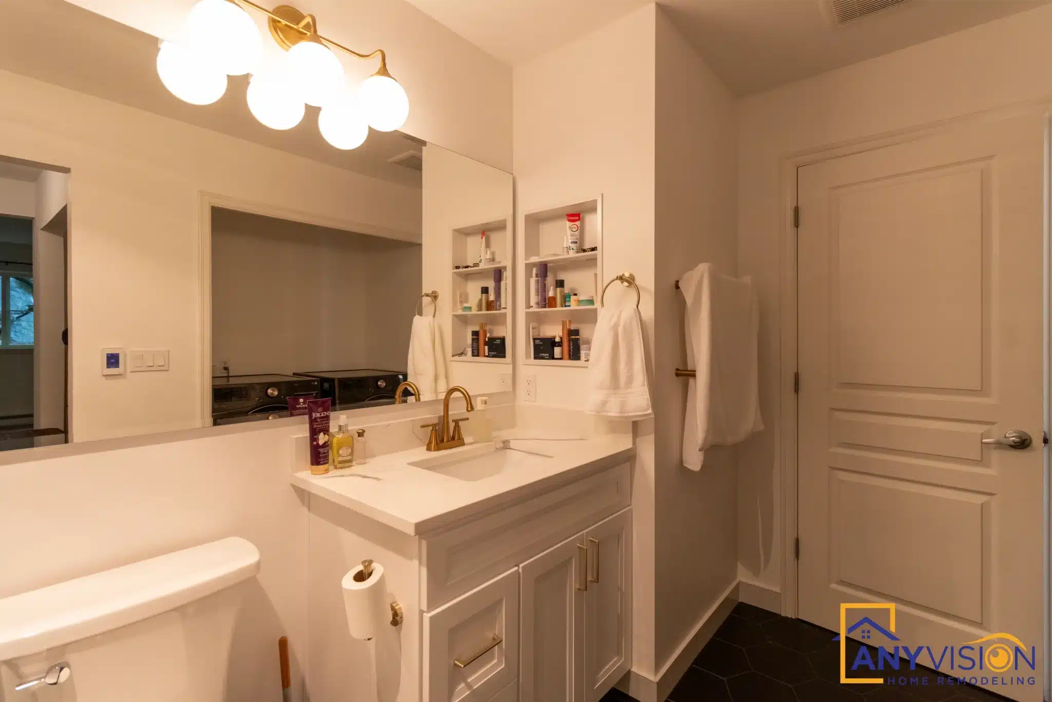 Vanity with white cabinetry and globe wall lighting