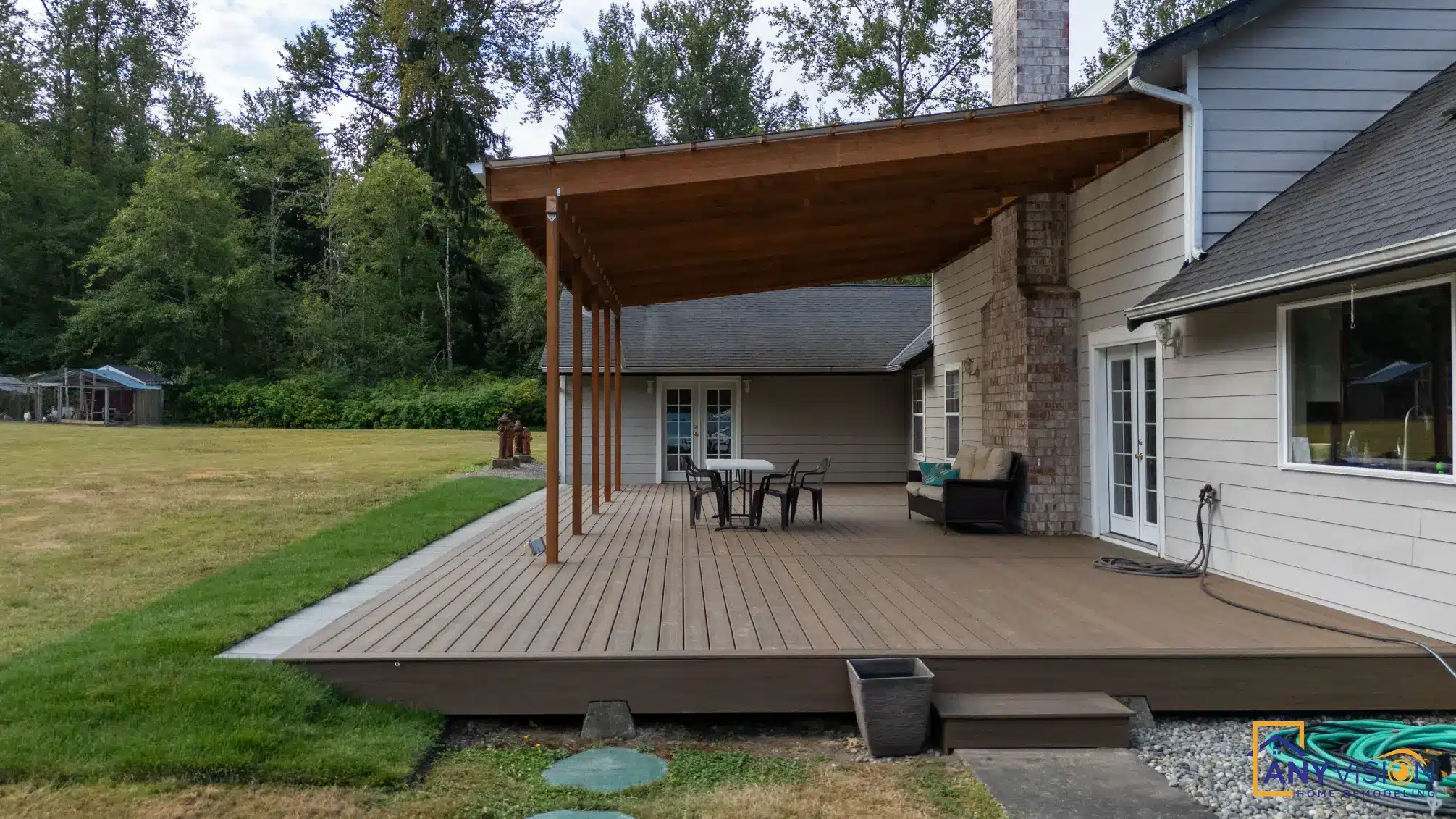 Covered deck seen from the lawn, showing the roof span and timber posts