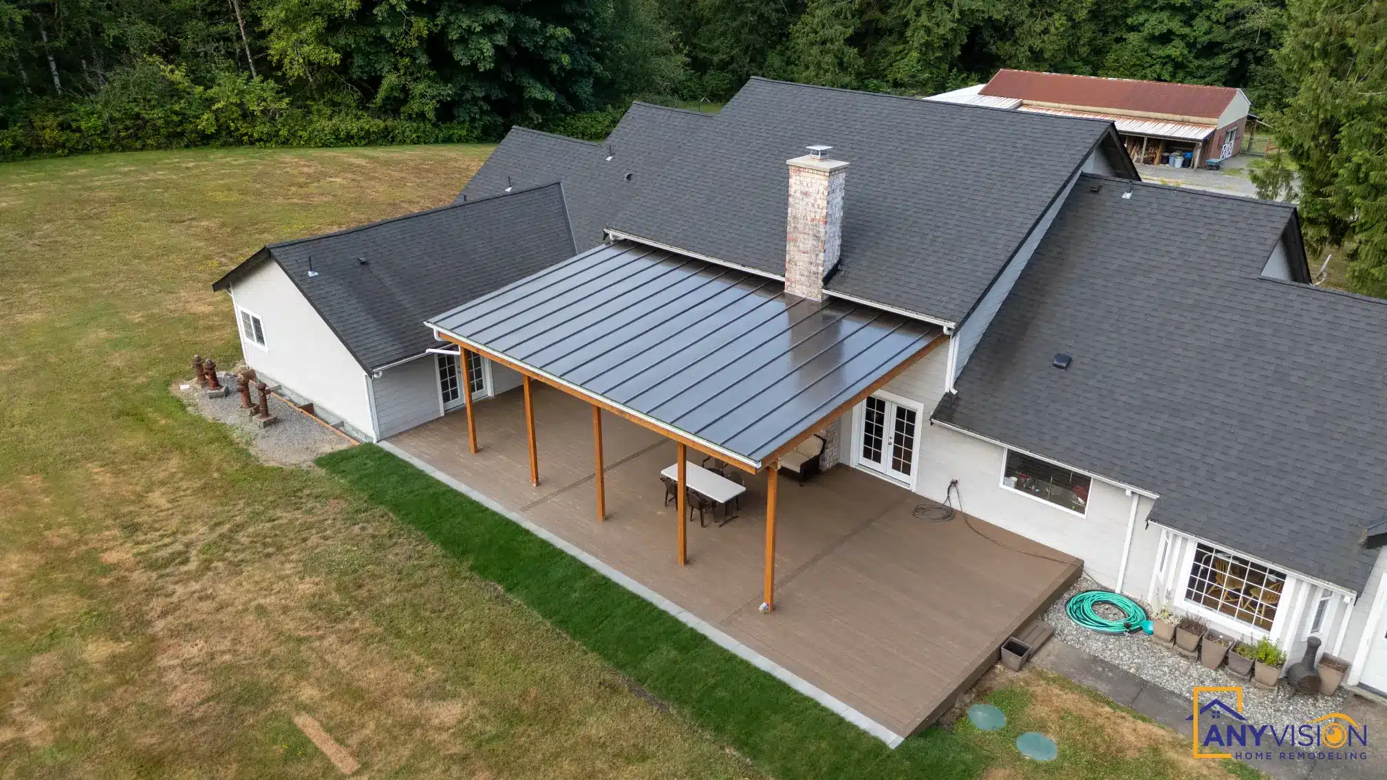 Aerial view of the covered deck and its metal roof against the main house