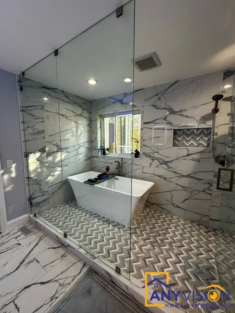 Freestanding tub against book-matched marble-look slab in Monroe