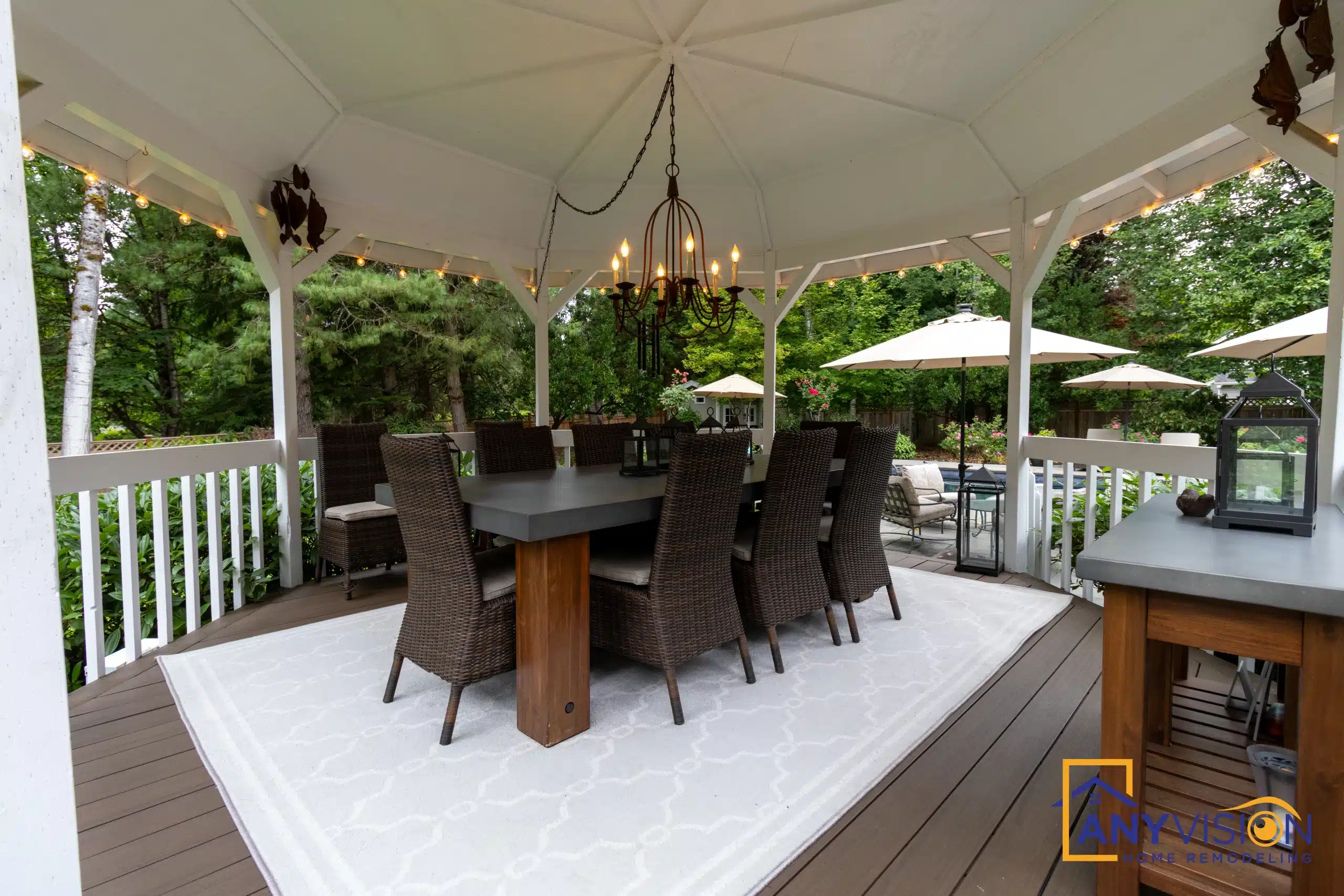 Covered outdoor dining area with a long table and hanging light fixture