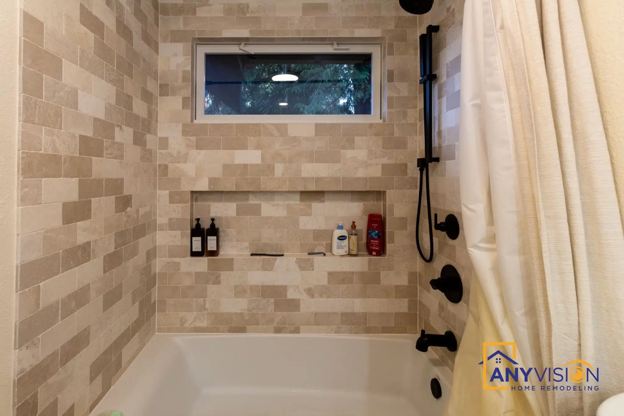 Tiled shower with a recessed niche and matte black fittings