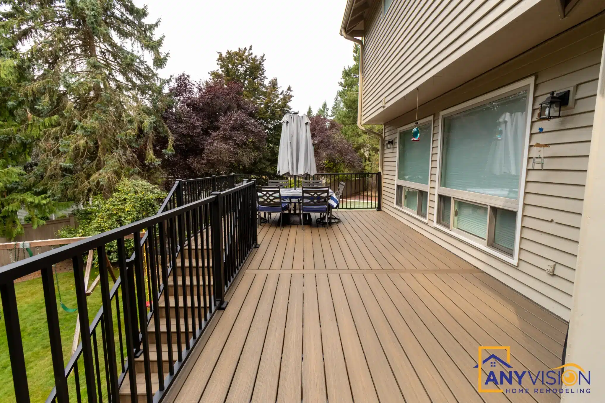 Deck running alongside the house with black metal railings