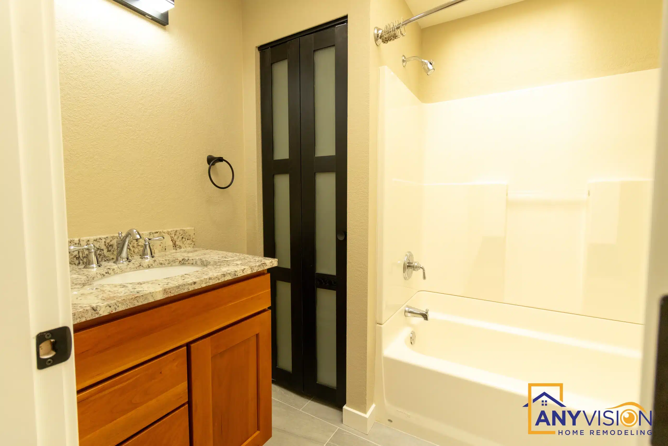 Renovated bathroom with a vanity, tub and dark-framed door