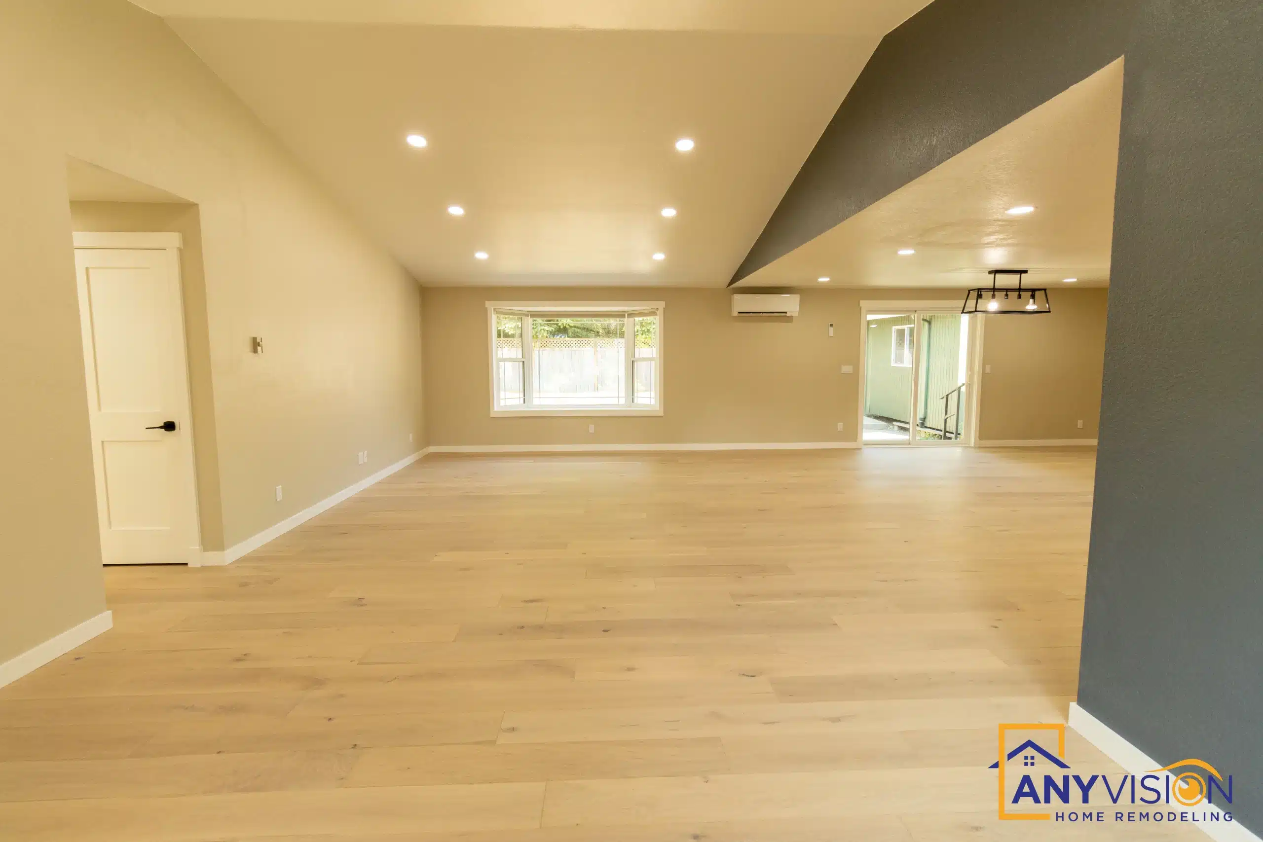 Open living room with new flooring and daylight from a full-height window