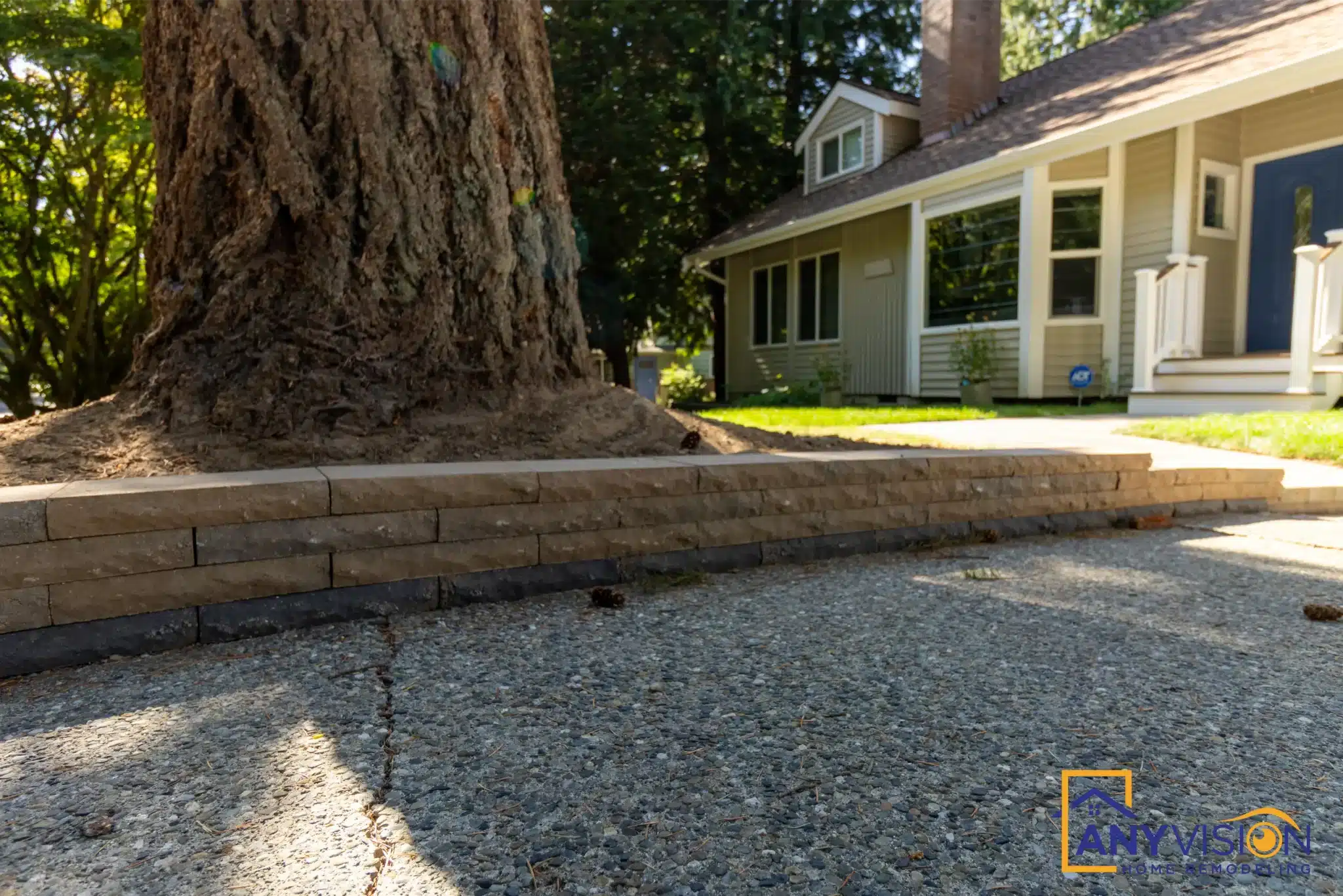 Retaining wall and gravel bed beside the mature conifer
