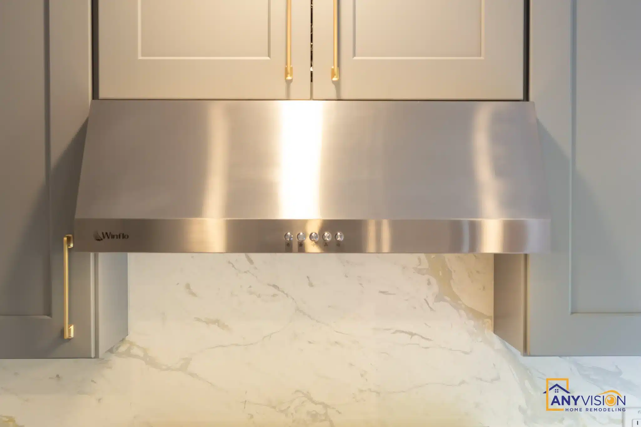 Stainless hood against a full-height quartz slab backsplash