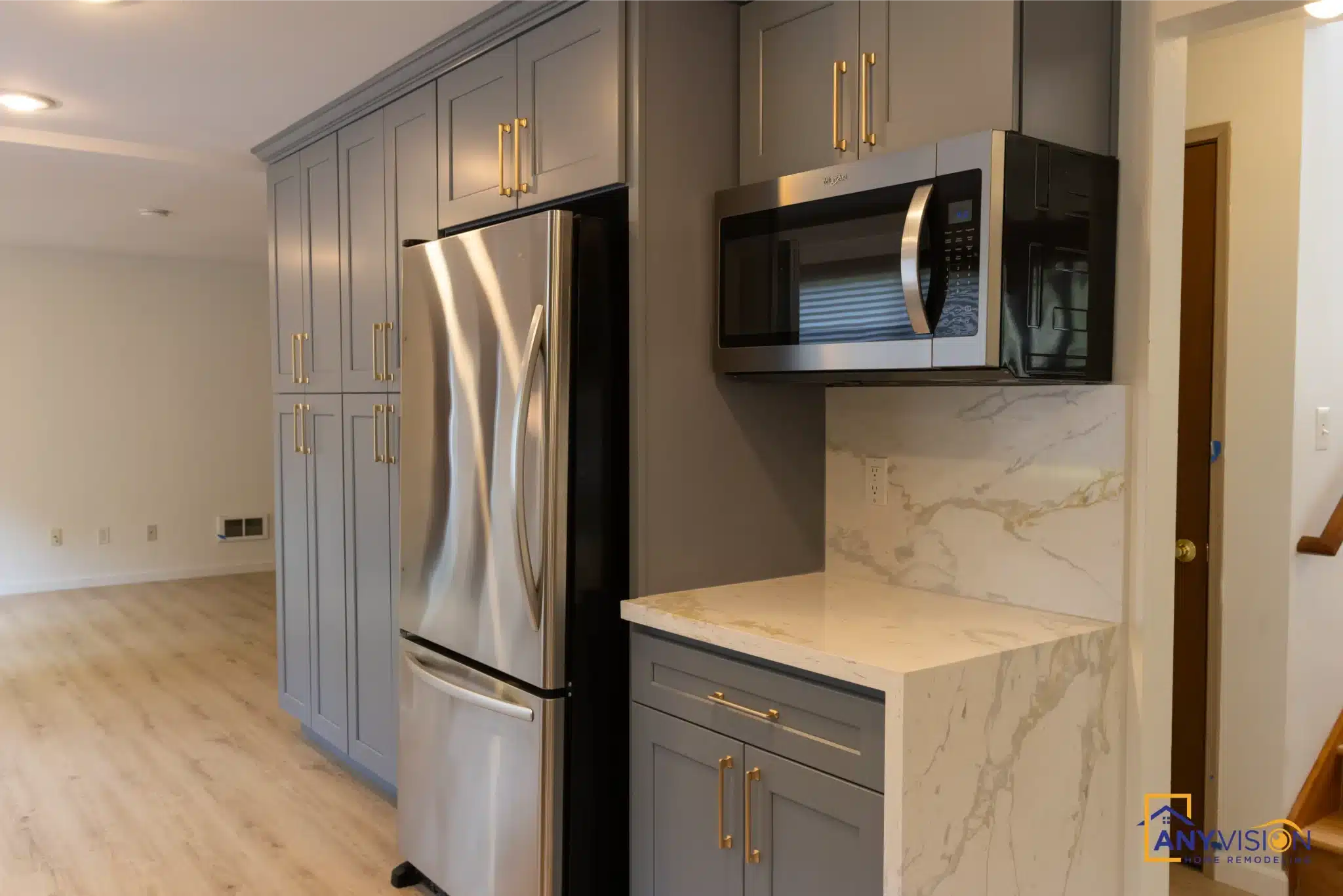 Full-height cabinet run beside the stainless refrigerator and microwave