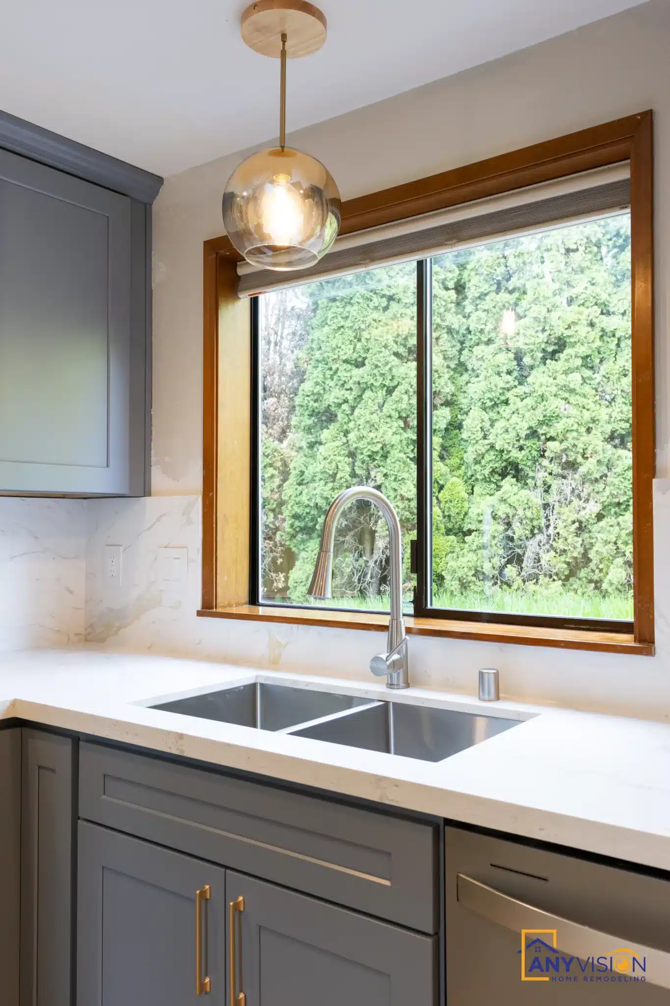Sink run beneath the retained stained-wood window with brass tapware