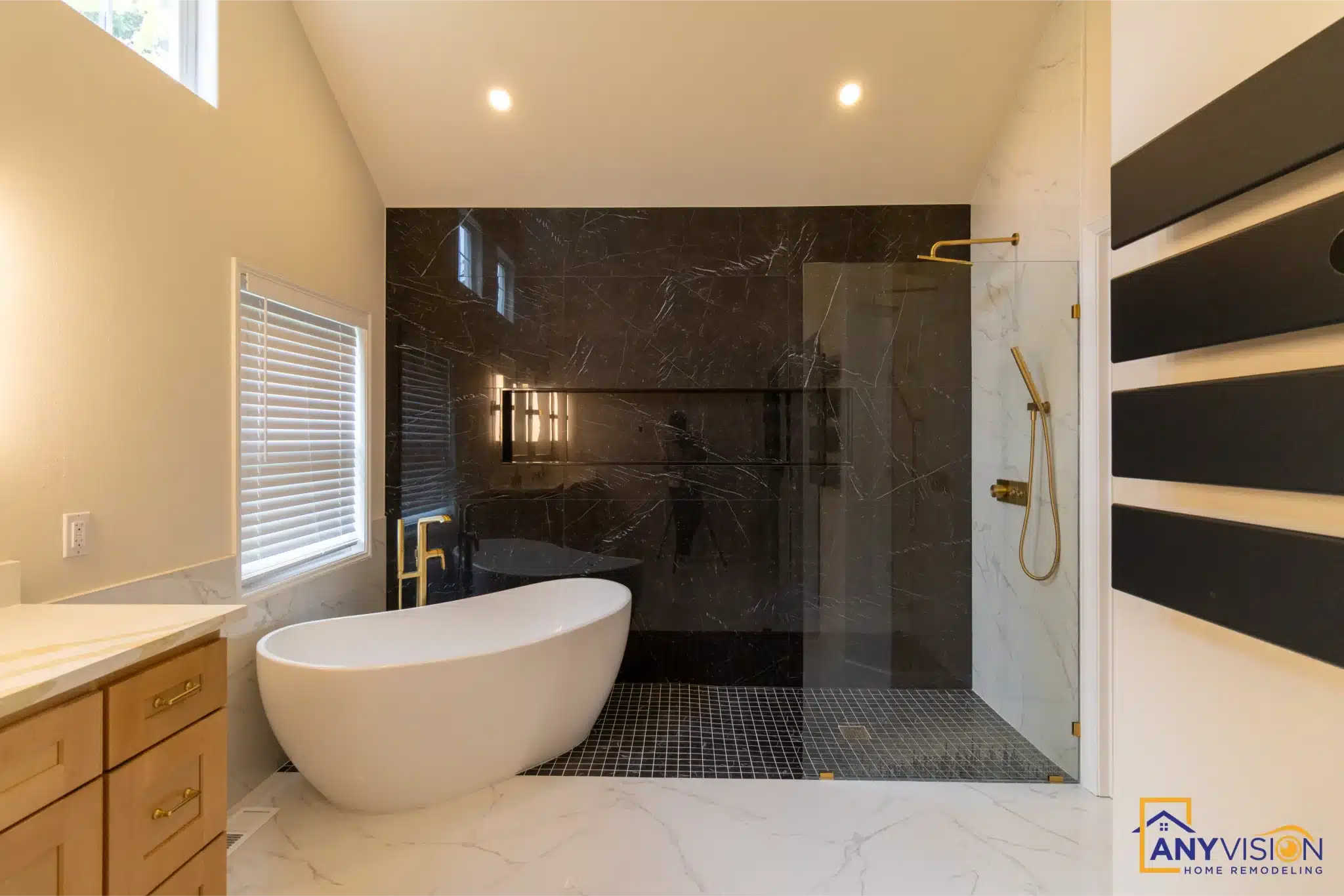 Freestanding tub set against the full-height black marble wall