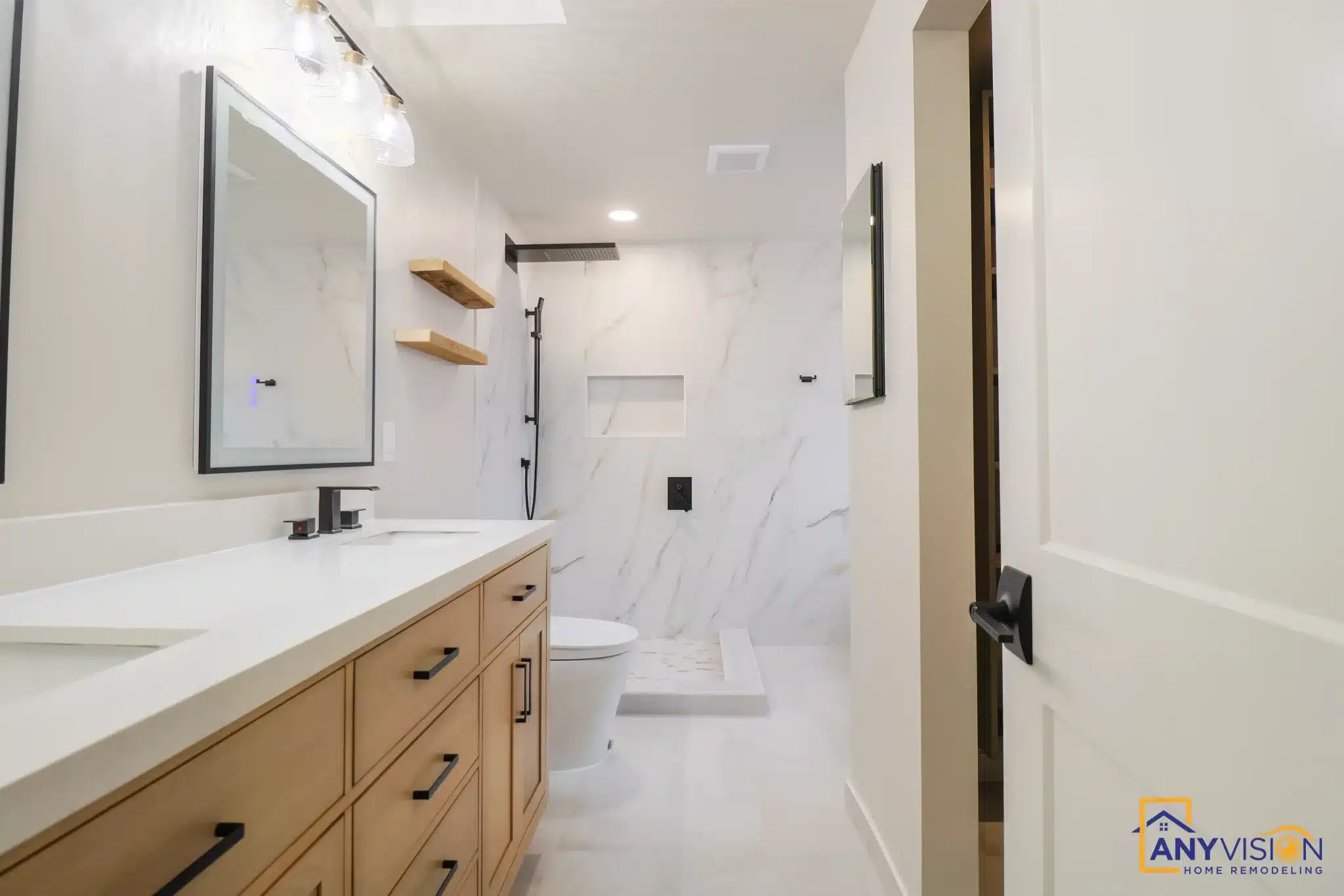 Long oak vanity run with a stone top and the walk-in shower beyond