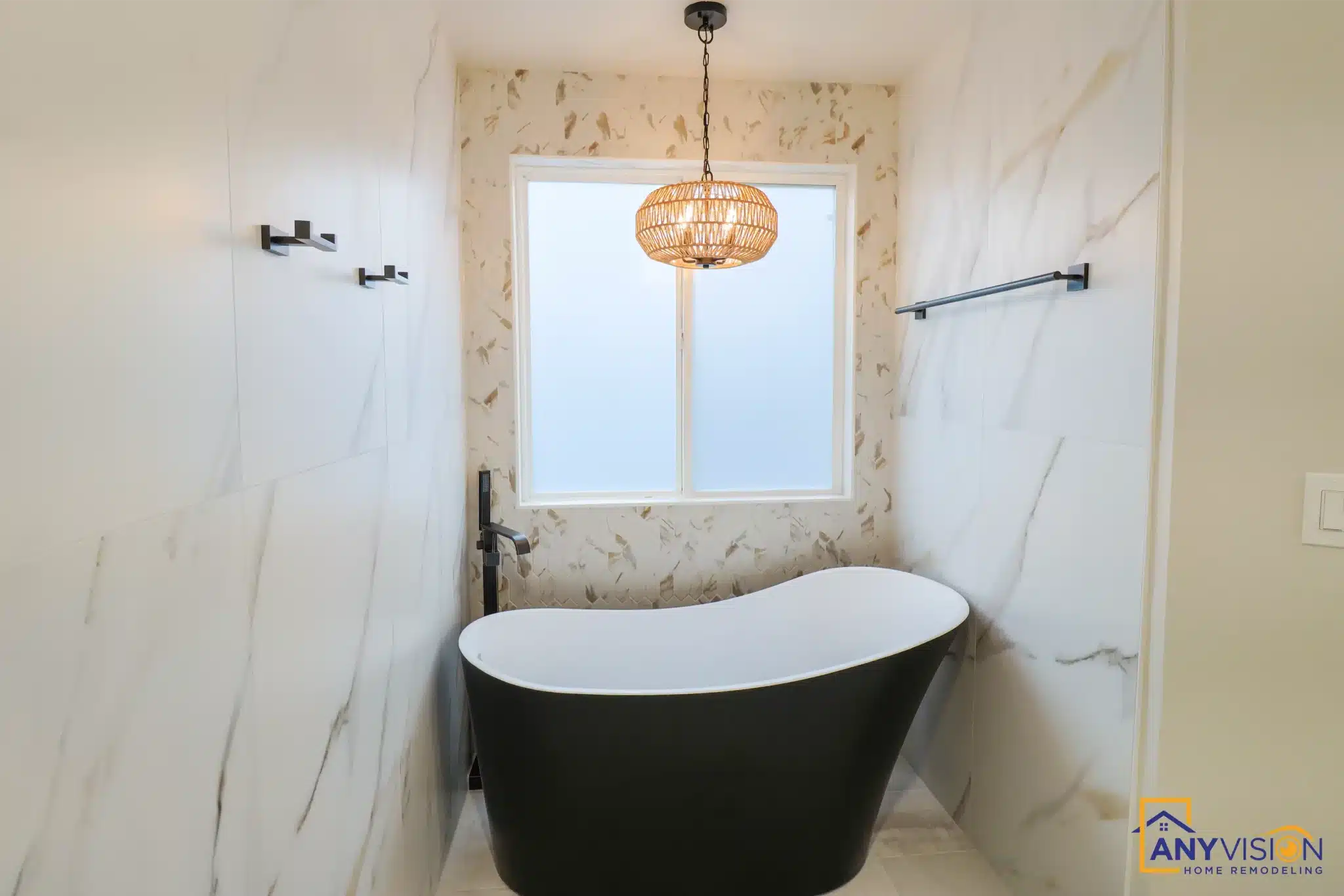 Freestanding black tub beneath a window with a woven pendant above, against ma