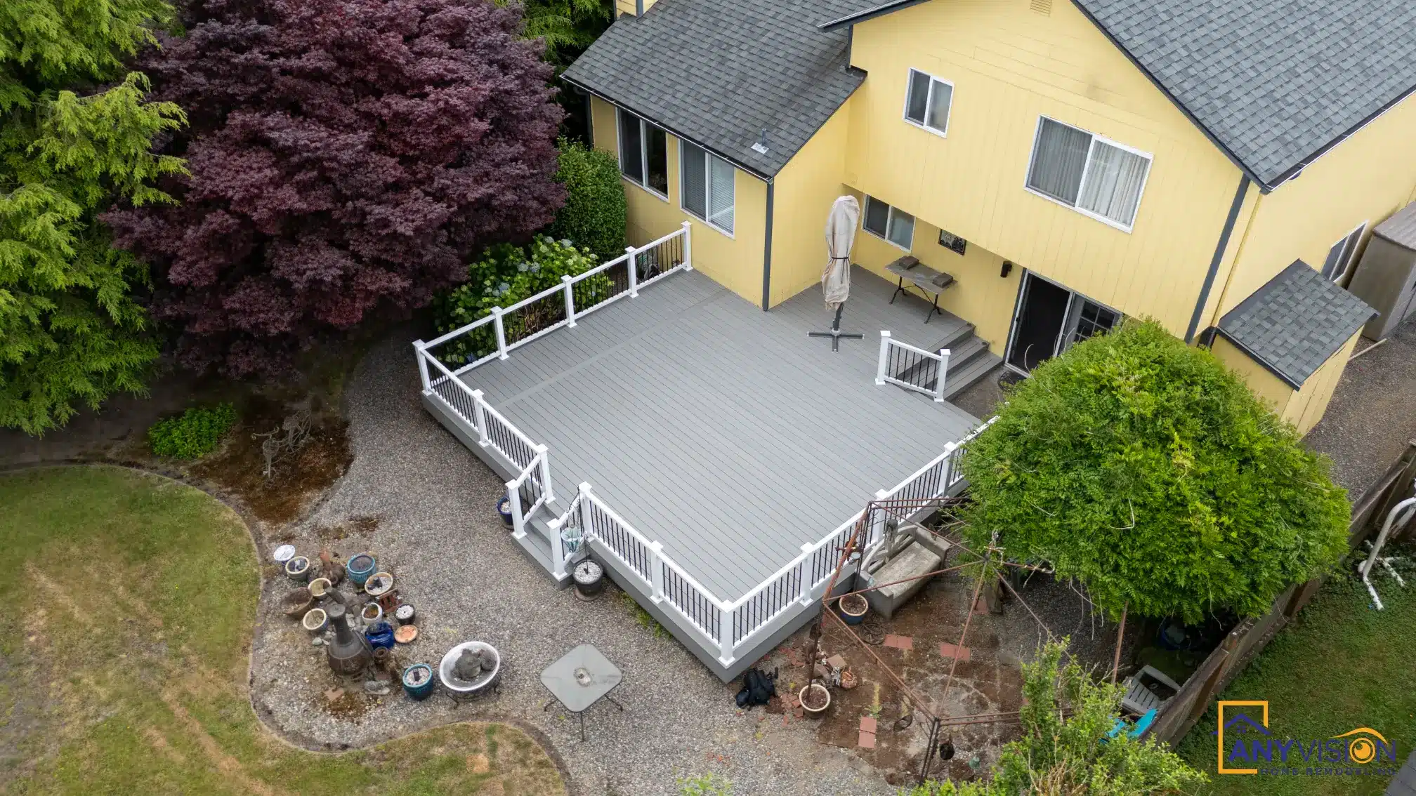 Rebuilt rear deck with white railings above a paved patio, Monroe WA