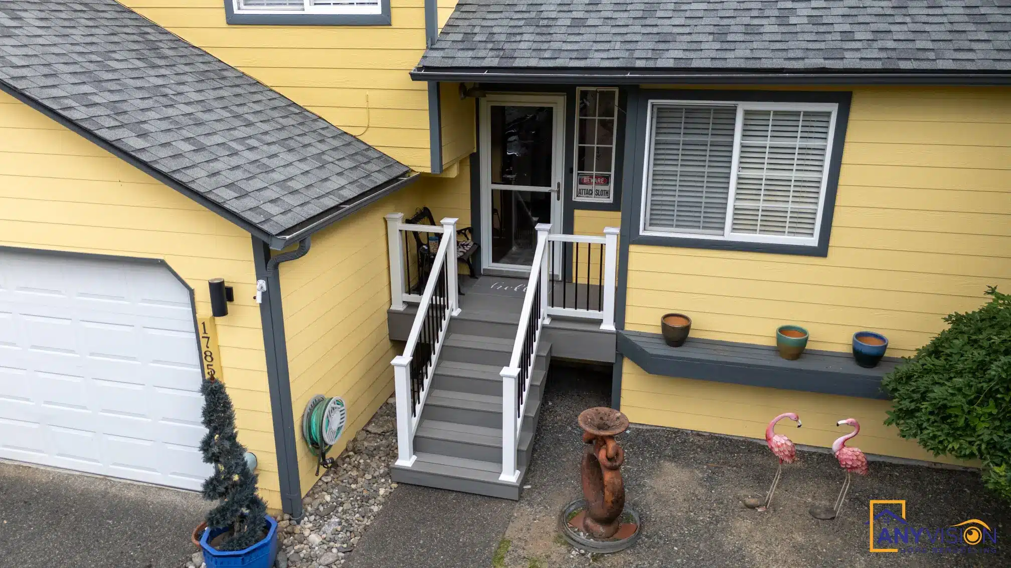 Front entry stairs with white railings beside the garage