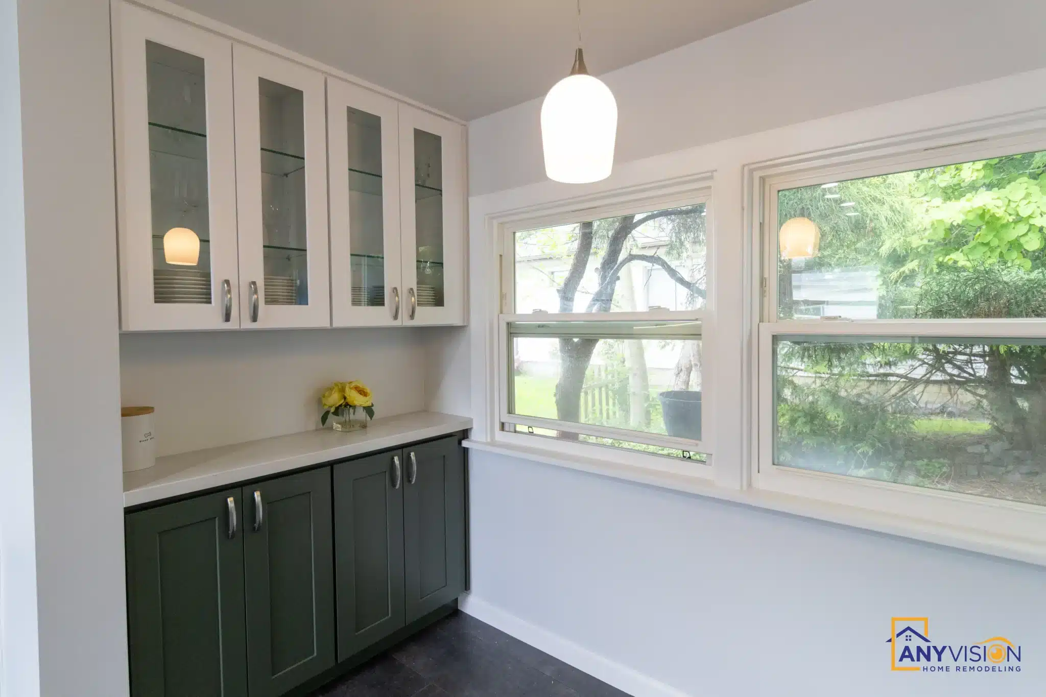 Sink run beneath the window with glass-front upper cabinets alongside