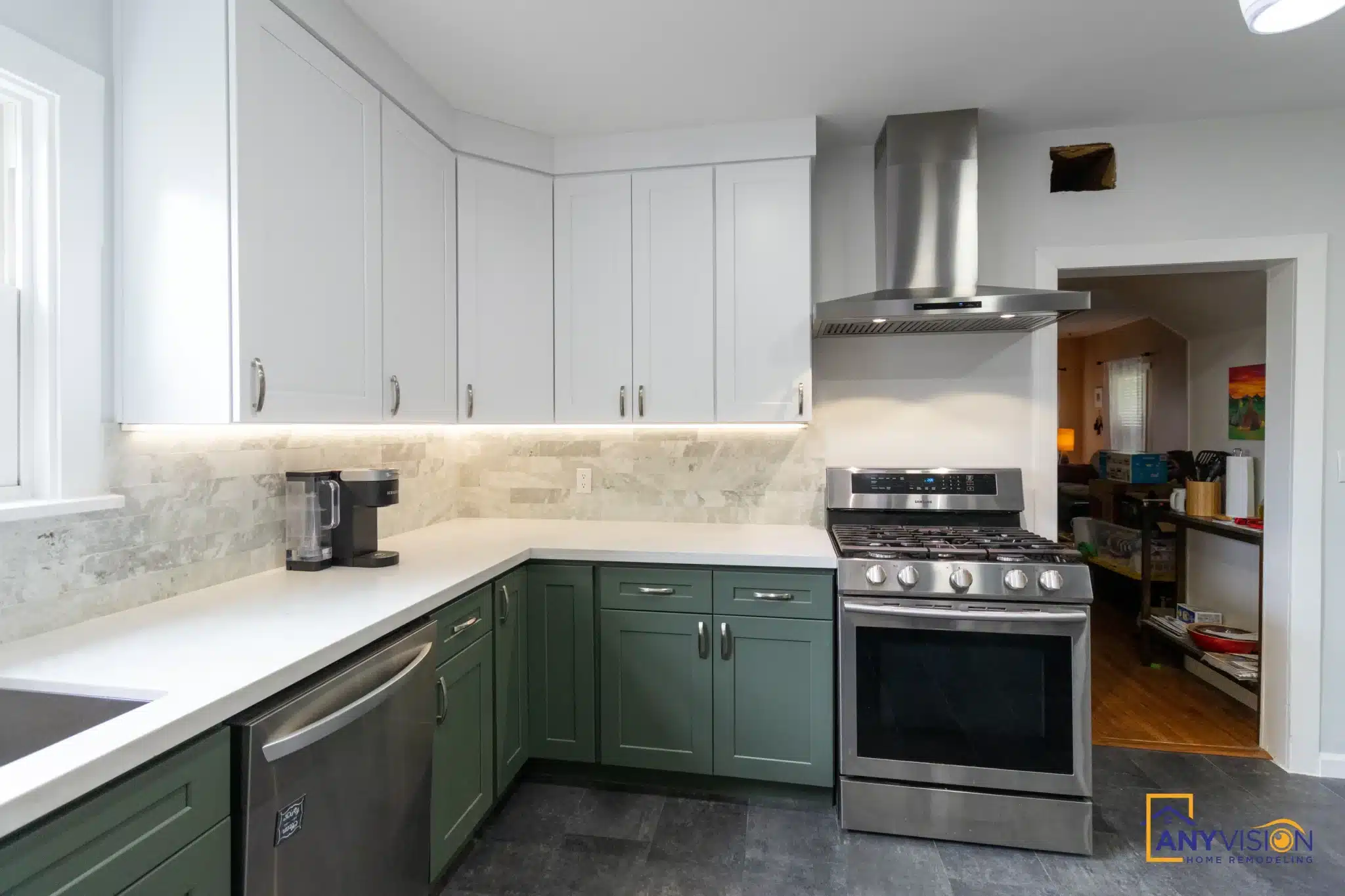 Gas range beneath a stainless chimney hood against the stone backsplash