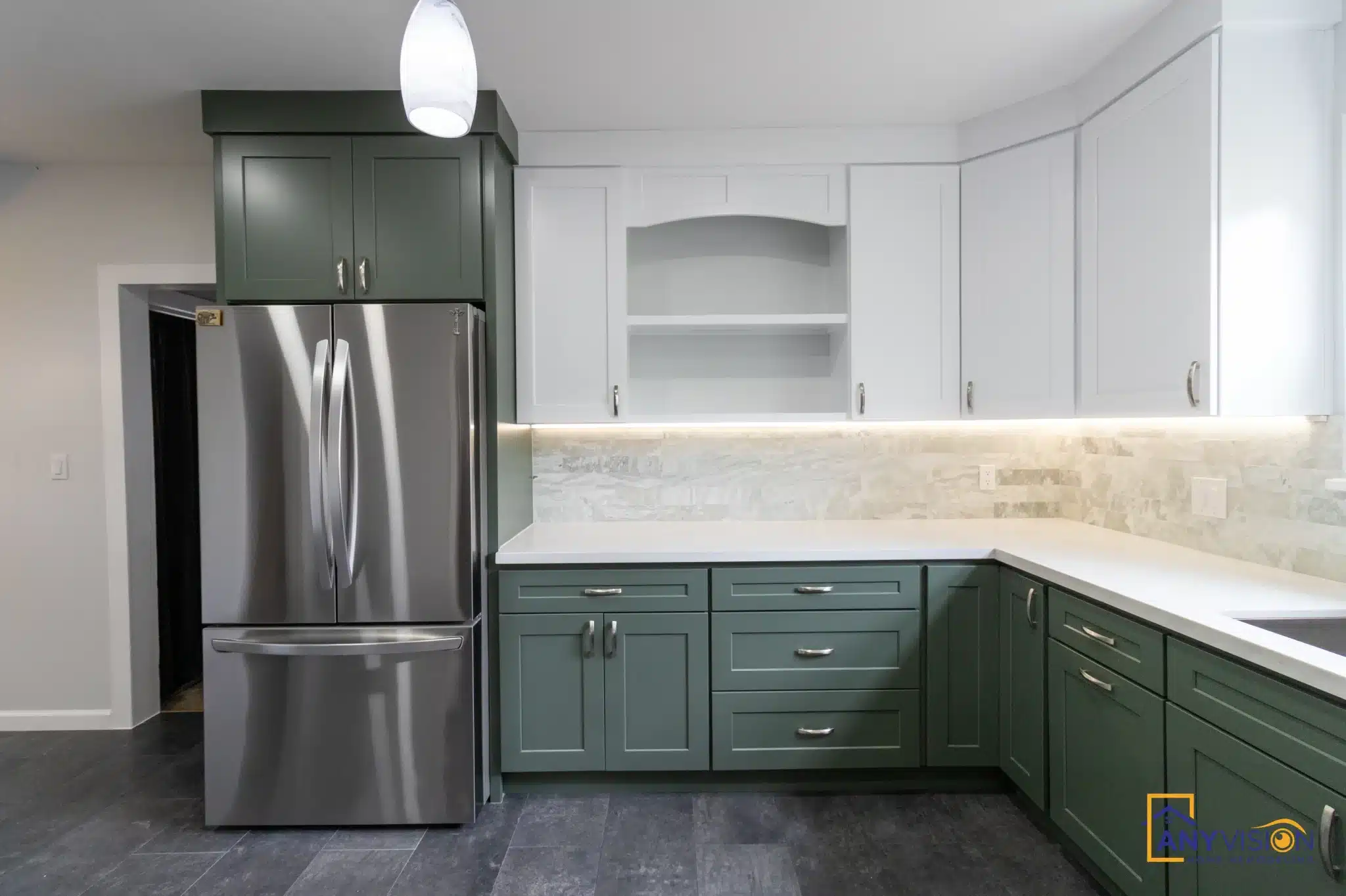 Arched open niche beside the refrigerator with white cabinetry above