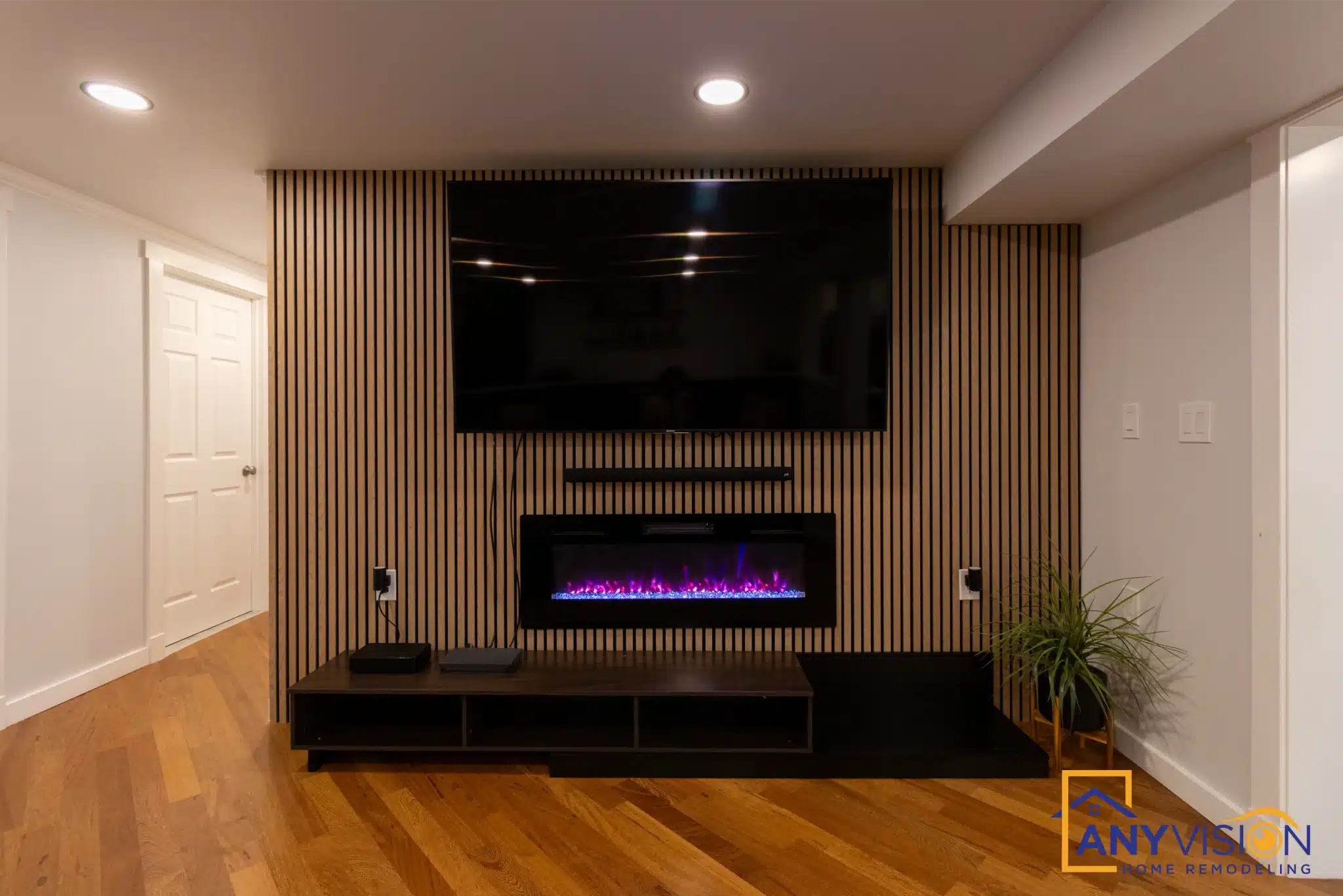 Slatted timber feature wall carrying a television and linear fireplace