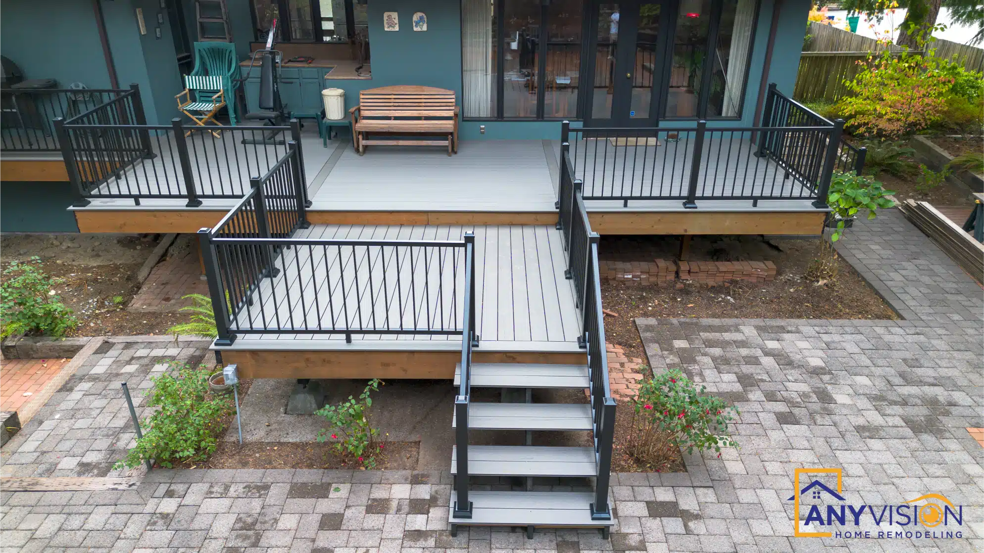 Stairs descending from the deck to the paver patio and garden below