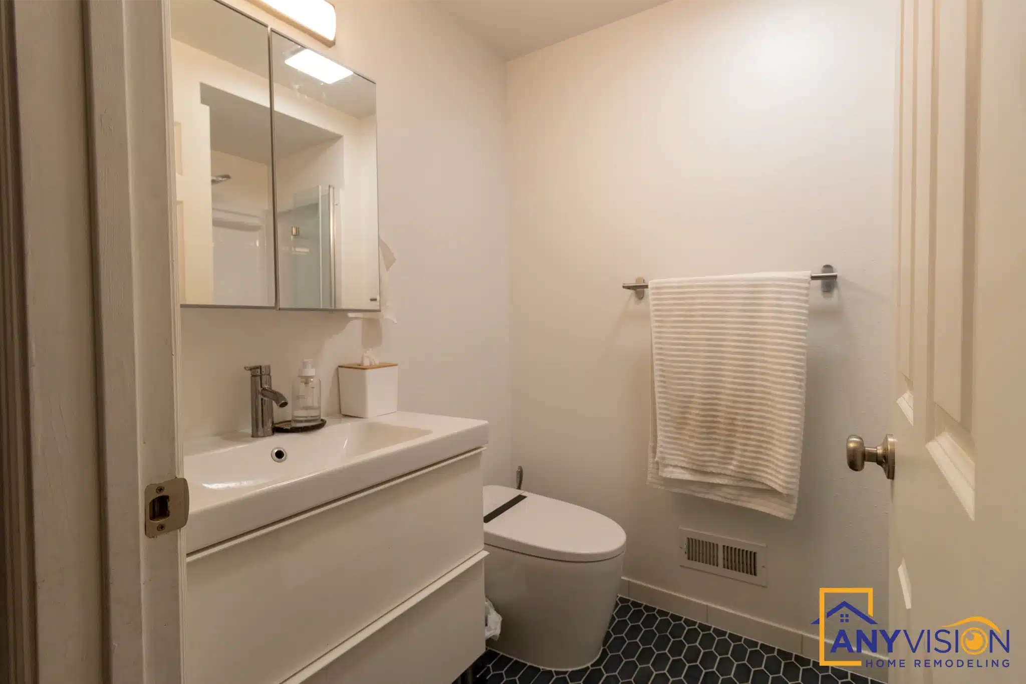 Second bathroom with white vanity, toilet and dark hex tile floor