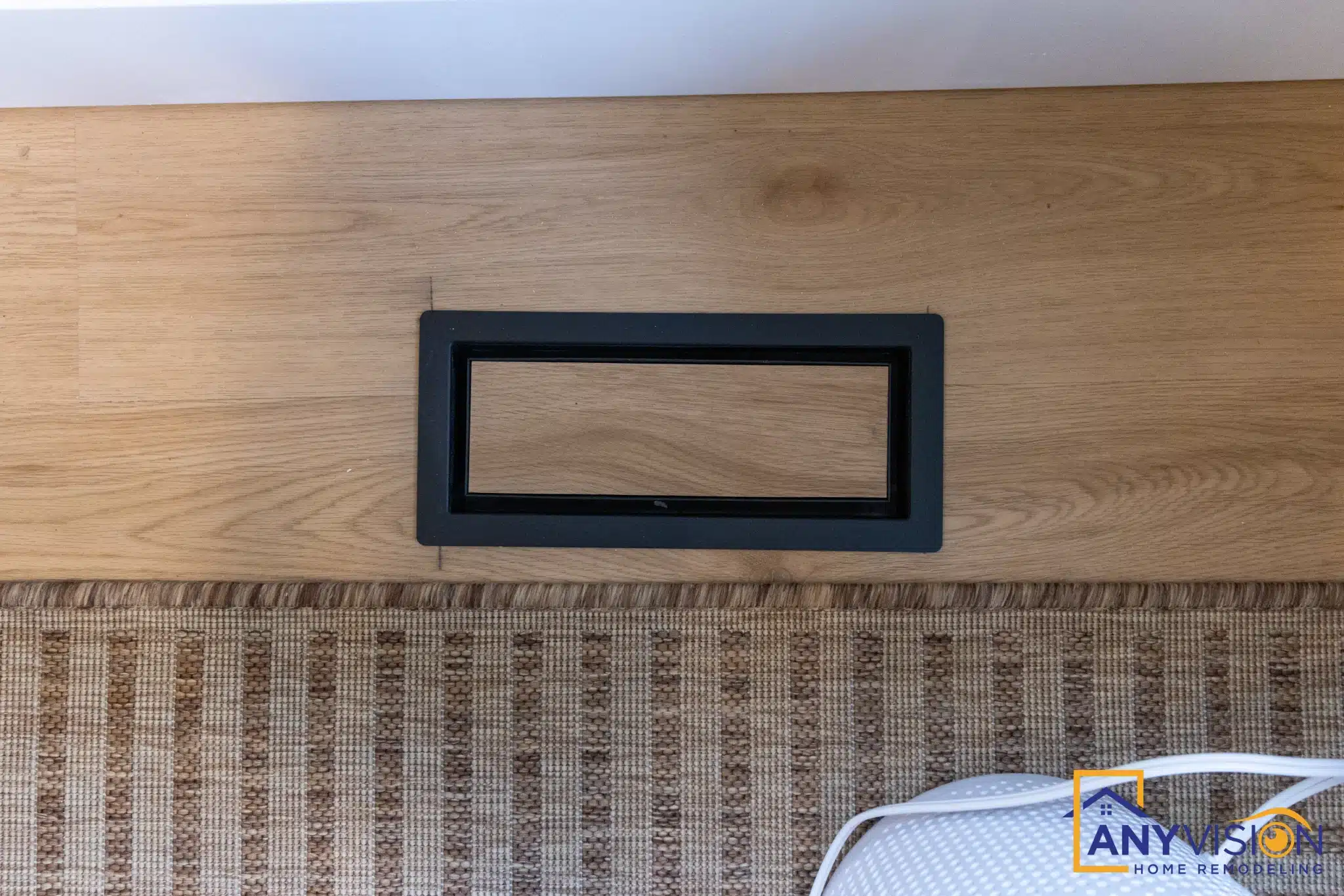 Linear fireplace set into a vertical timber-clad wall with textured tile beneath