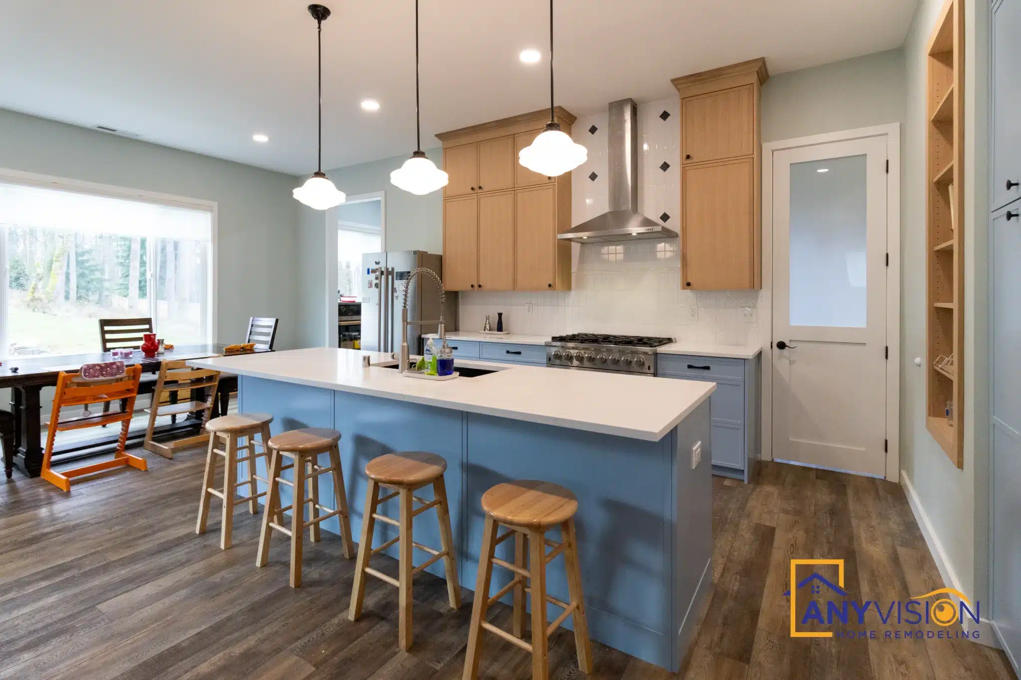 Island with stools and pendant lighting, looking across the open kitchen