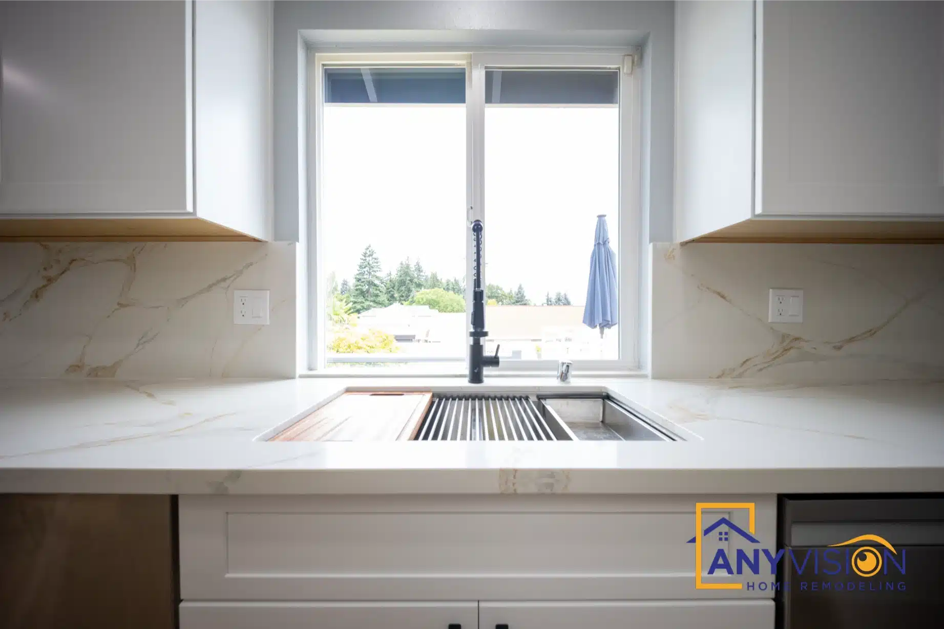Sink beneath the window with the quartz backsplash carried up behind