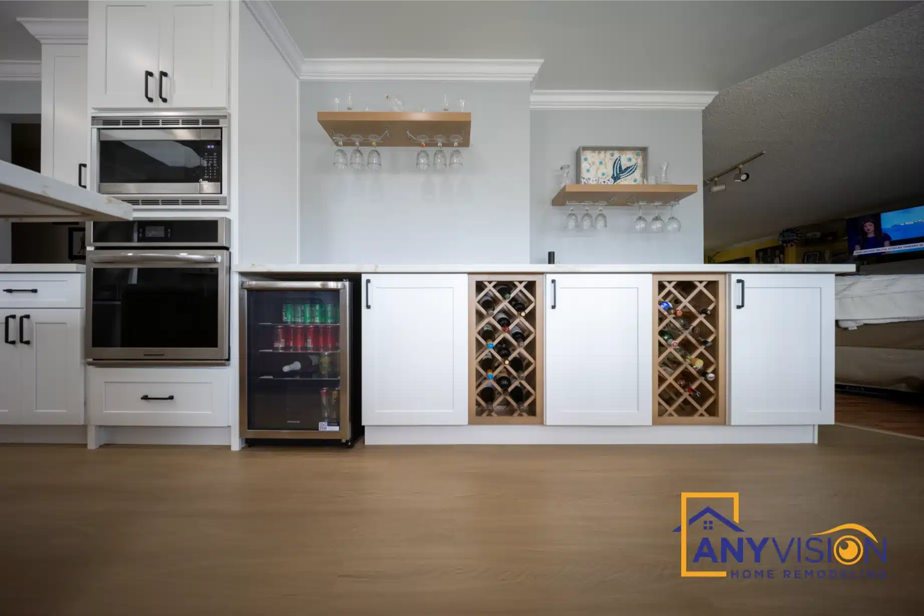 Stacked wall ovens and microwave beside integrated wine storage