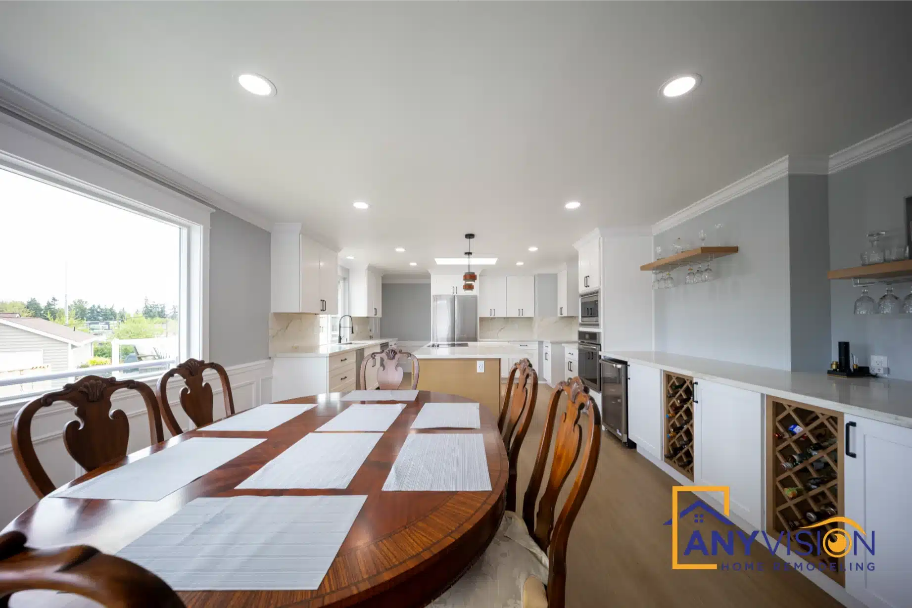 Dining table with the kitchen and island beyond