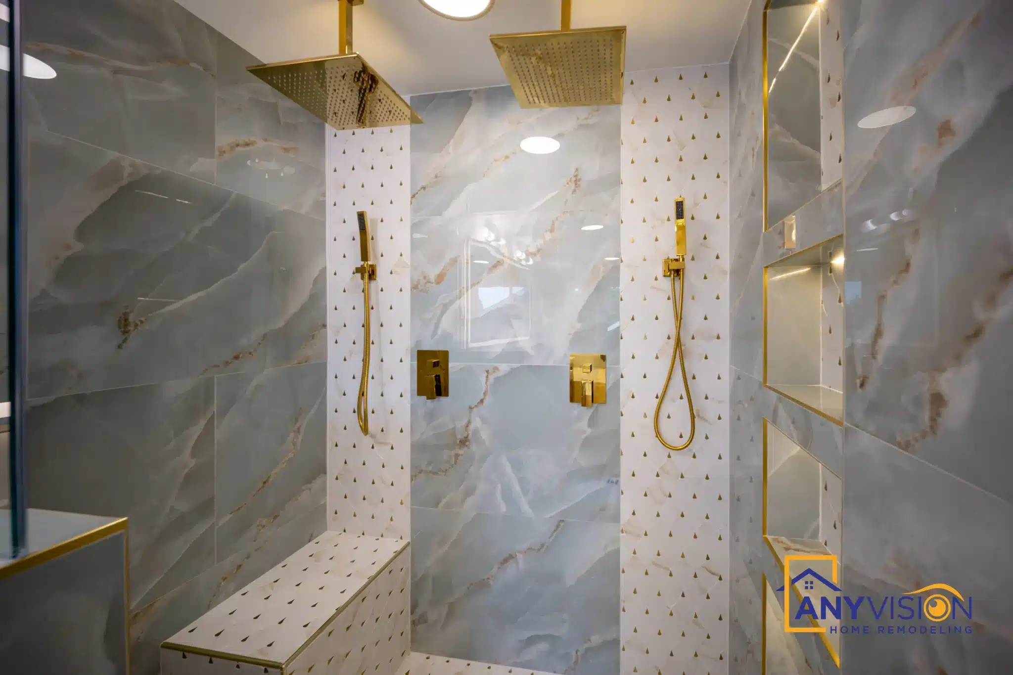 Shower interior showing the full run of gold fittings against grey slab