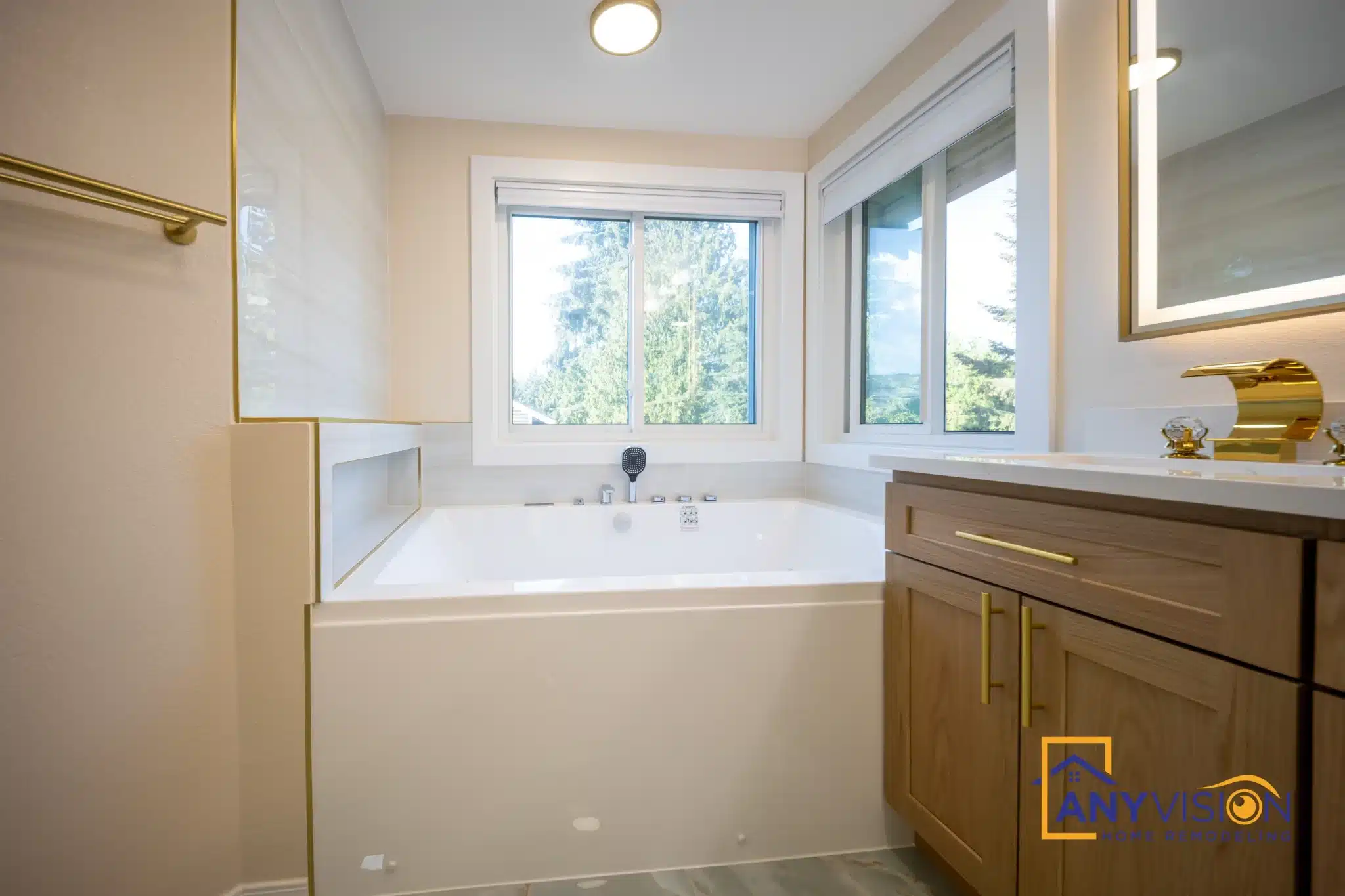Wood vanity with stone top beside the tub, windows above