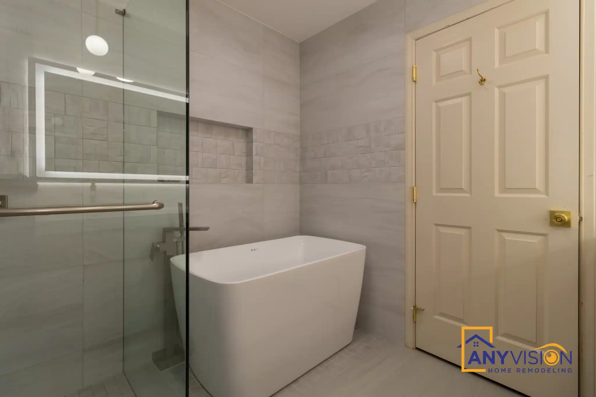 Freestanding tub beside the frameless glass shower enclosure