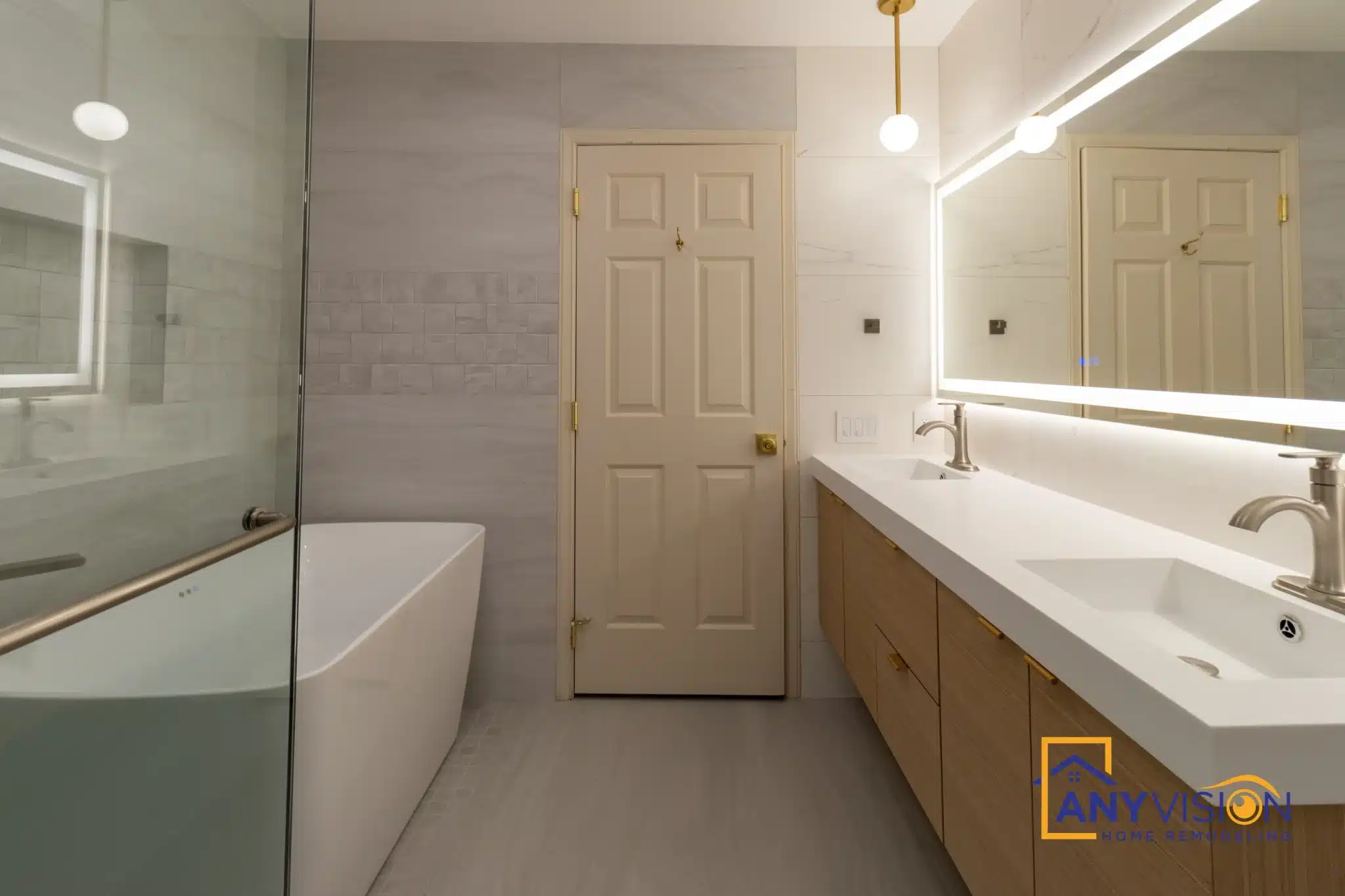 Full-width backlit mirror above the double vanity with the tub alongside