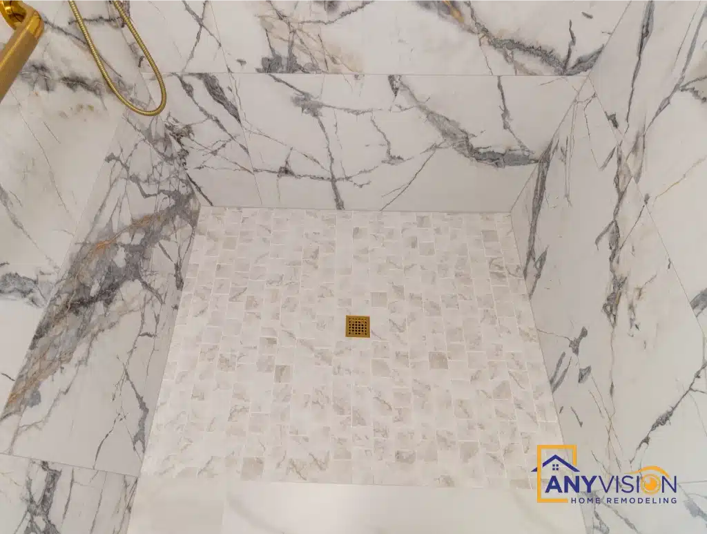 Level-threshold shower floor in hexagonal tile with brass drain