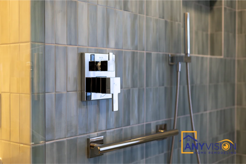 Shower controls and grab rail against the variegated blue tile