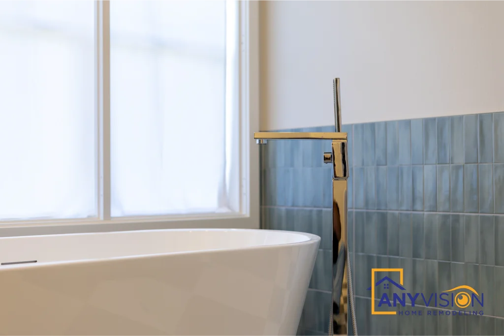 Freestanding tub beneath the window with floor-mounted filler