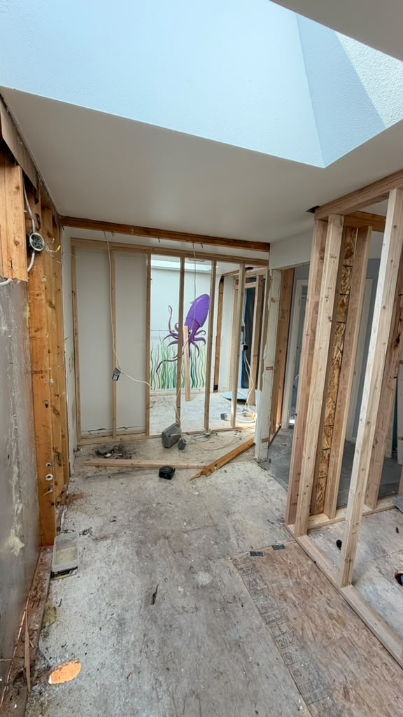 Exposed wall studs and ceiling joists during a split-level kitchen demolition in Redmond WA