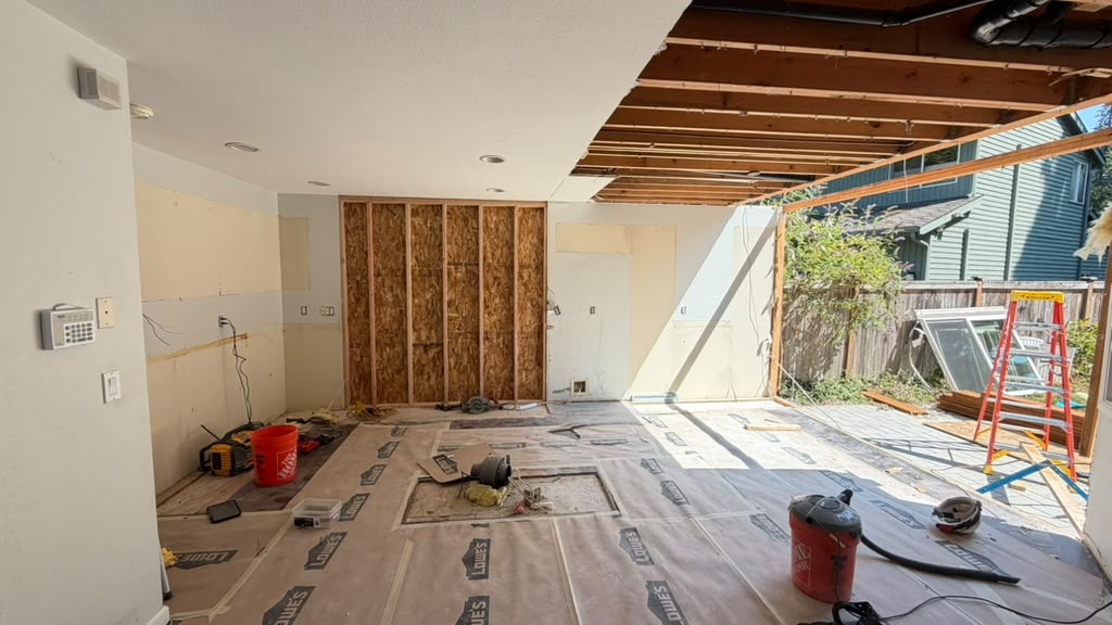 Ceiling joists and framing exposed during a load-bearing wall removal in a Redmond split-level