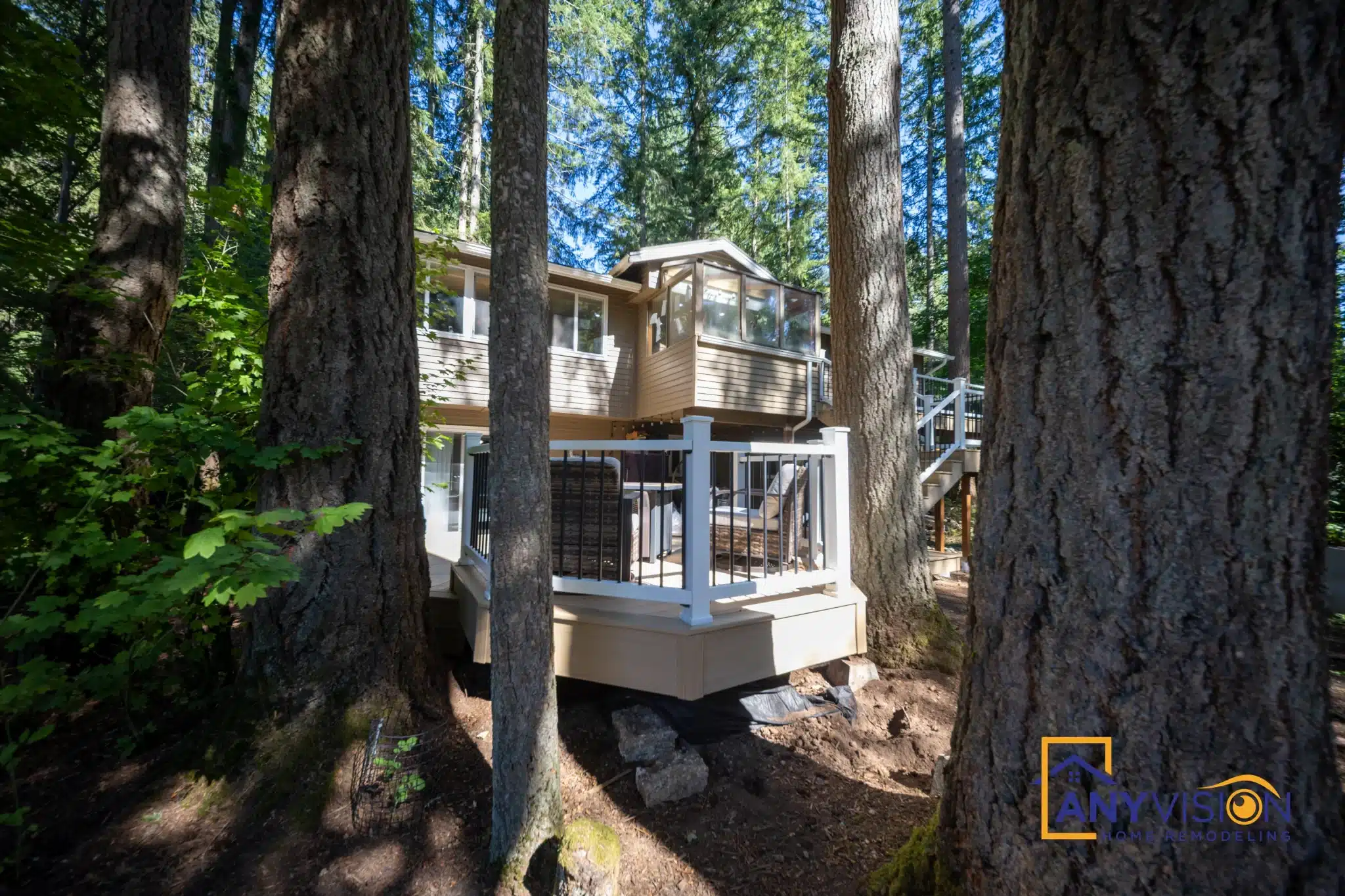 The deck seen through mature evergreens from the lower garden