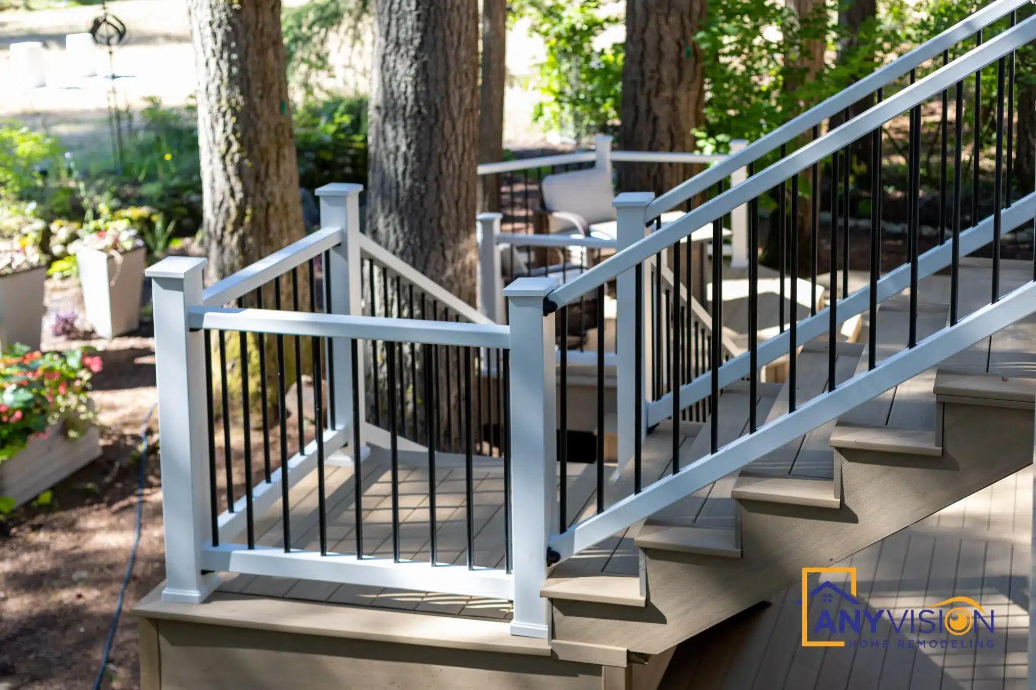 Stair flight with white posts and black metal balusters beside the house