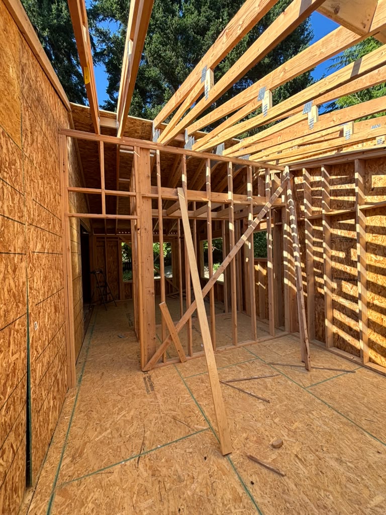 Redmond home stripped to the studs during a full remodel, with original wall framing and ceiling trusses exposed