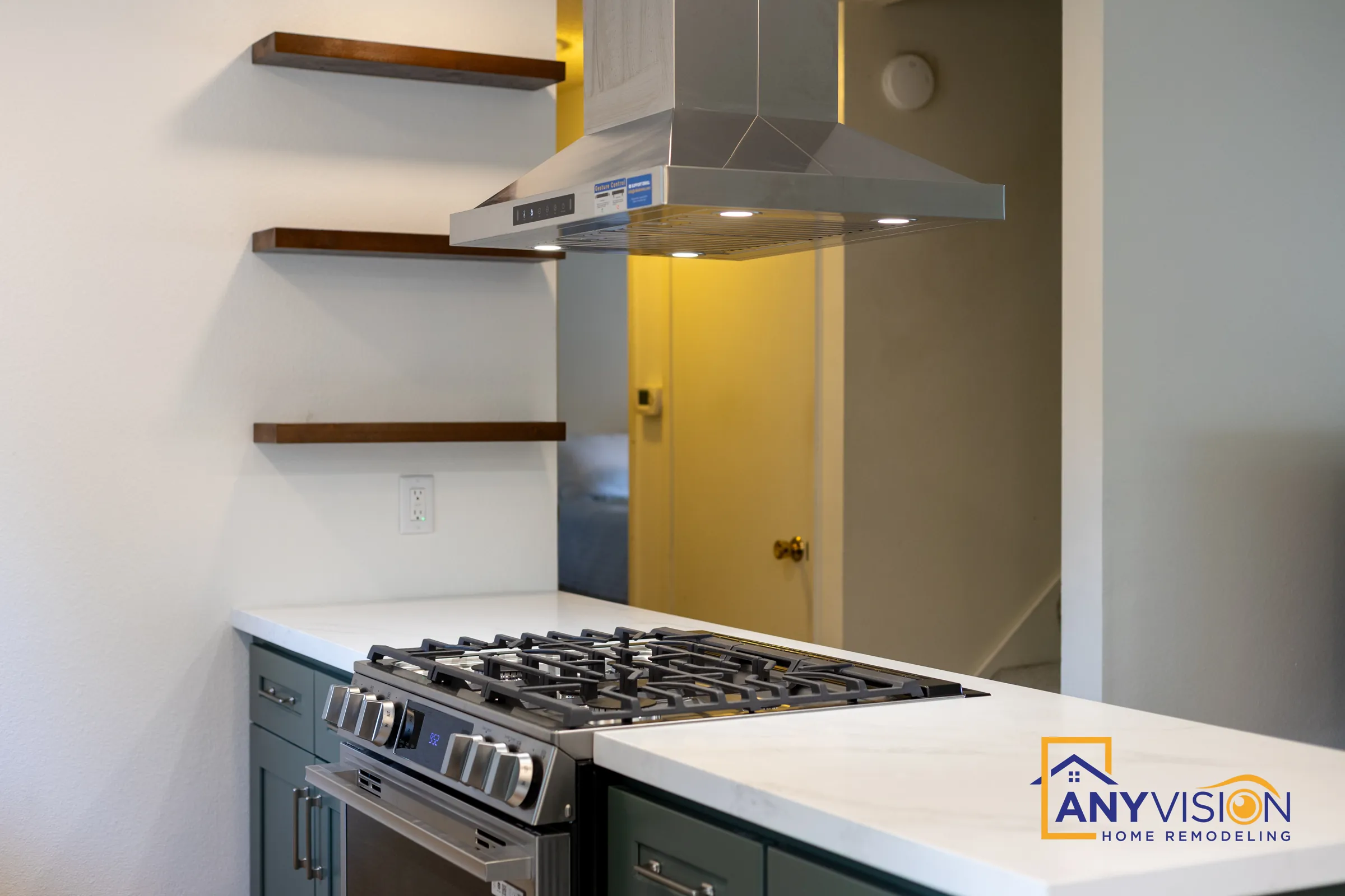 Stainless island hood over a gas range with walnut floating shelves