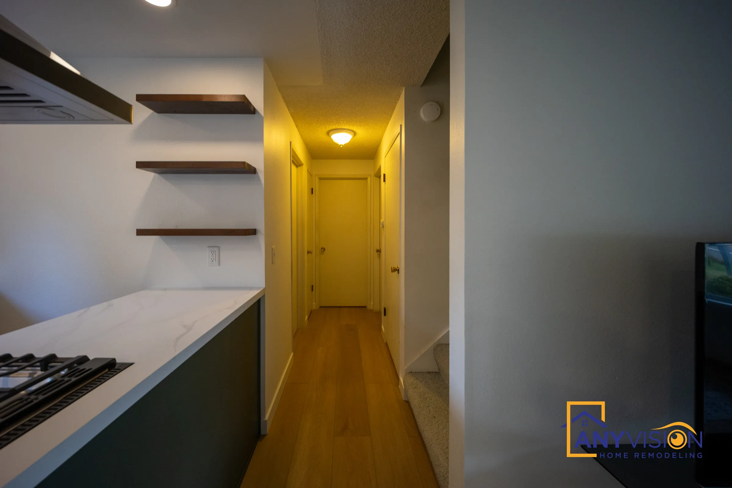 Walnut floating shelves at the end of the kitchen looking down the hallway