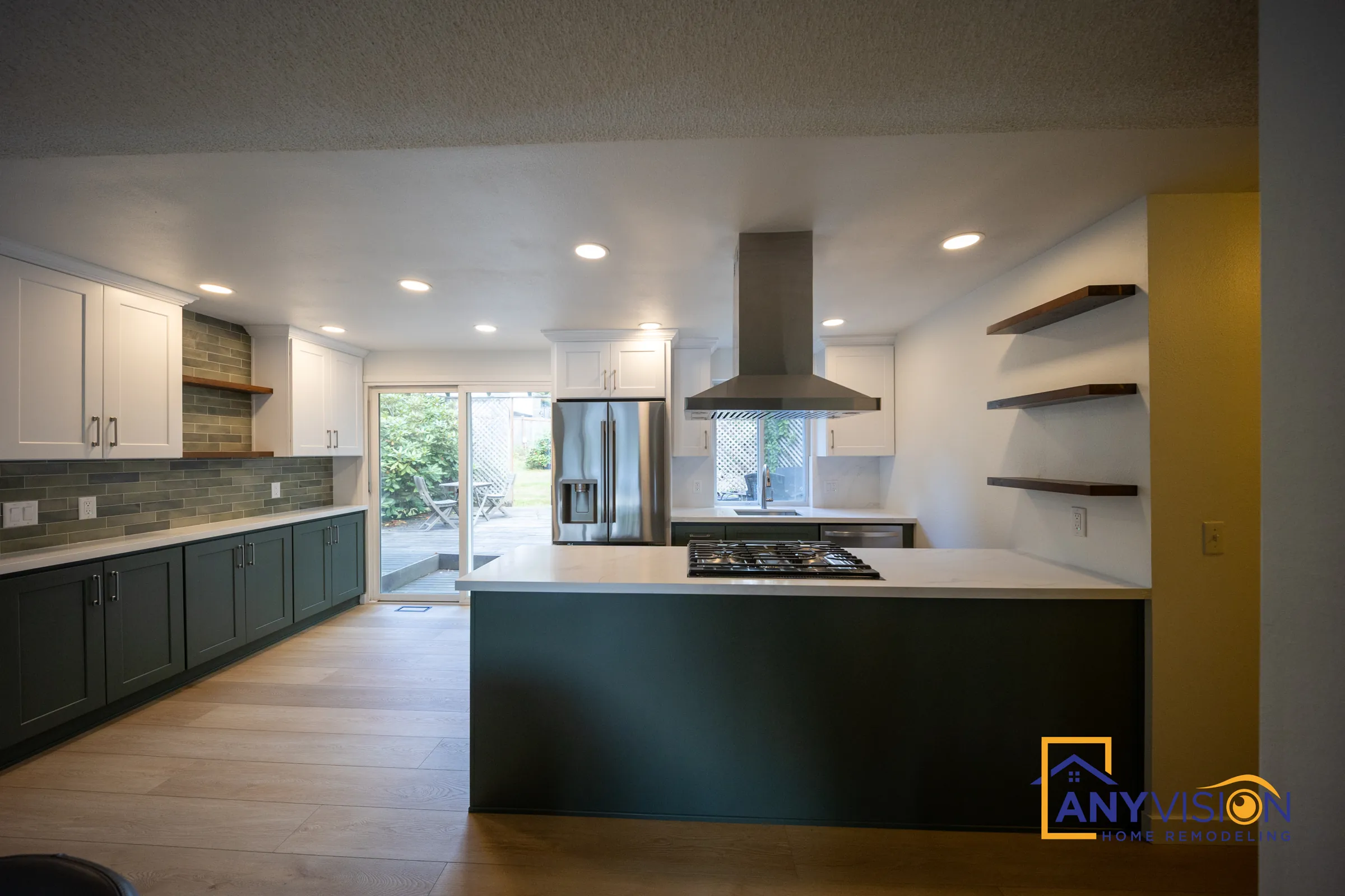 Remodeled kitchen with deep green cabinets and a cooktop island in Lake Forest Park, built by Anyvision